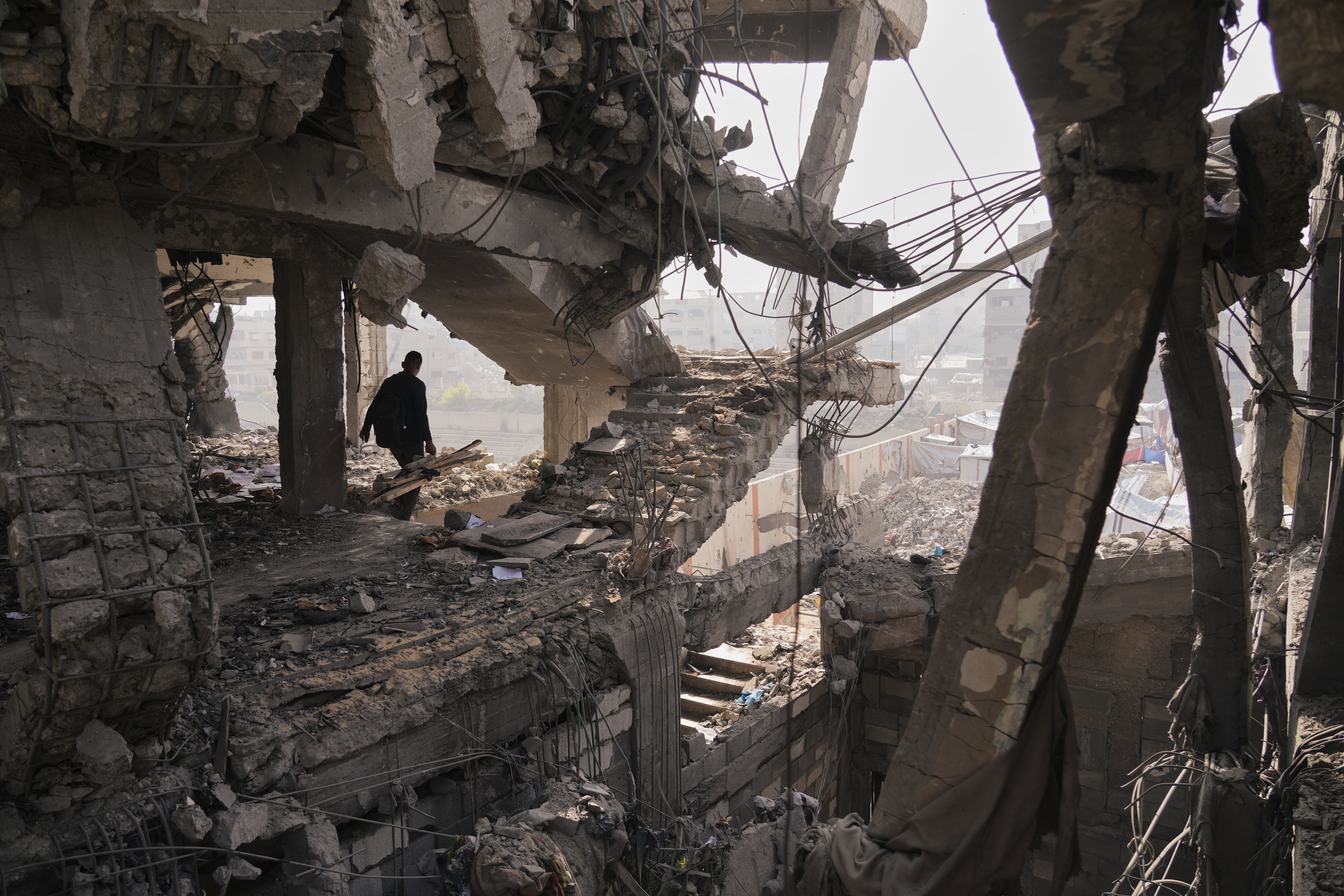 <p>Palestinians inspect the ruins a day after an Israeli strike on a building in Gaza City</p>