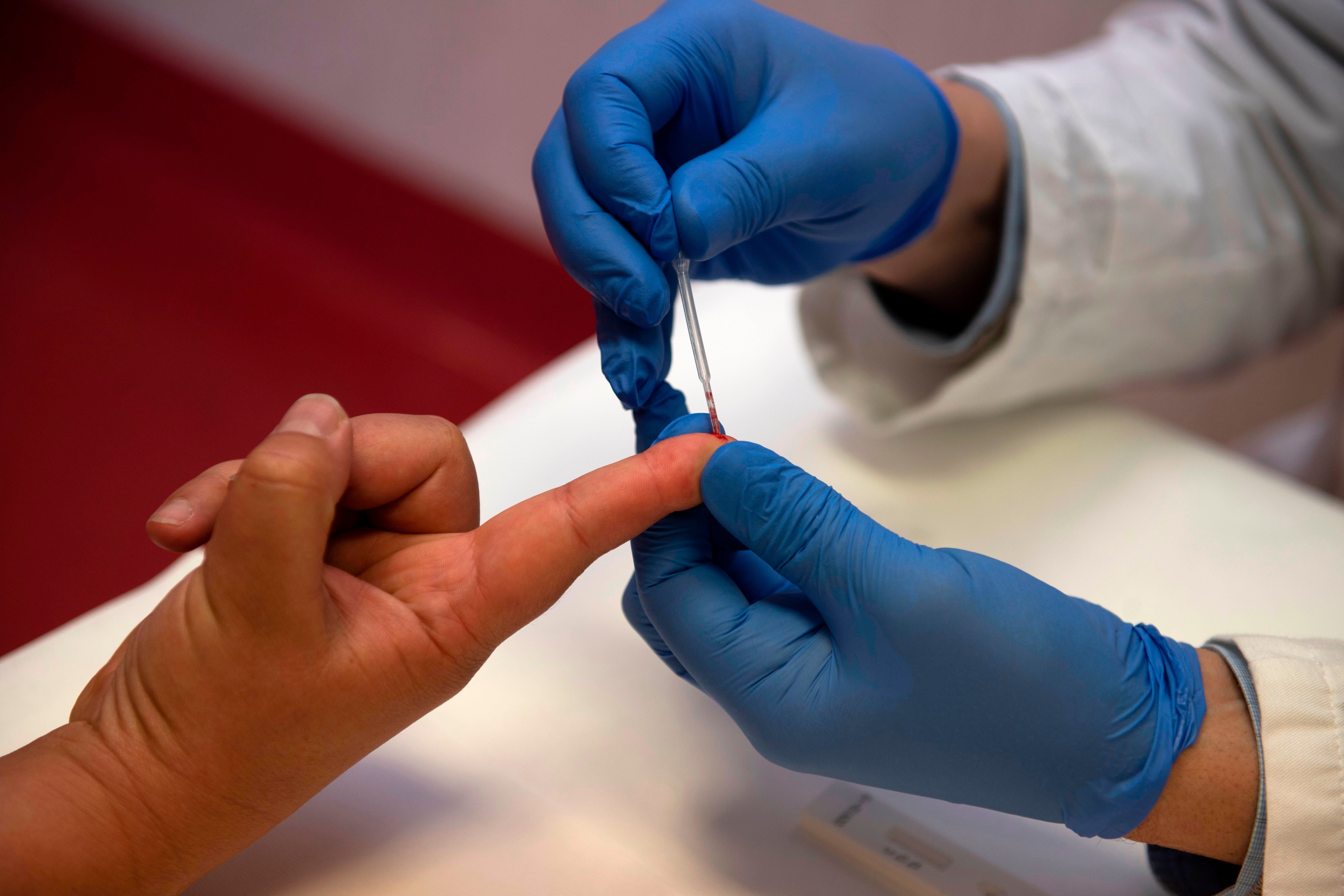 Person undergoes a finger prick blood sample collection