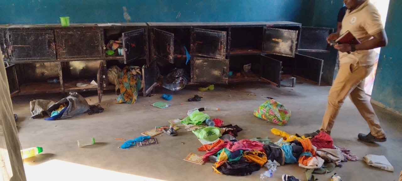 In this photo released by Christian Association of Nigeria, a man walk past belongings at the St. Mary's Catholic Primary and Secondary School after gunmen abducted children and staff in Papiri community, Nigeria, Friday, Nov. 21, 2025