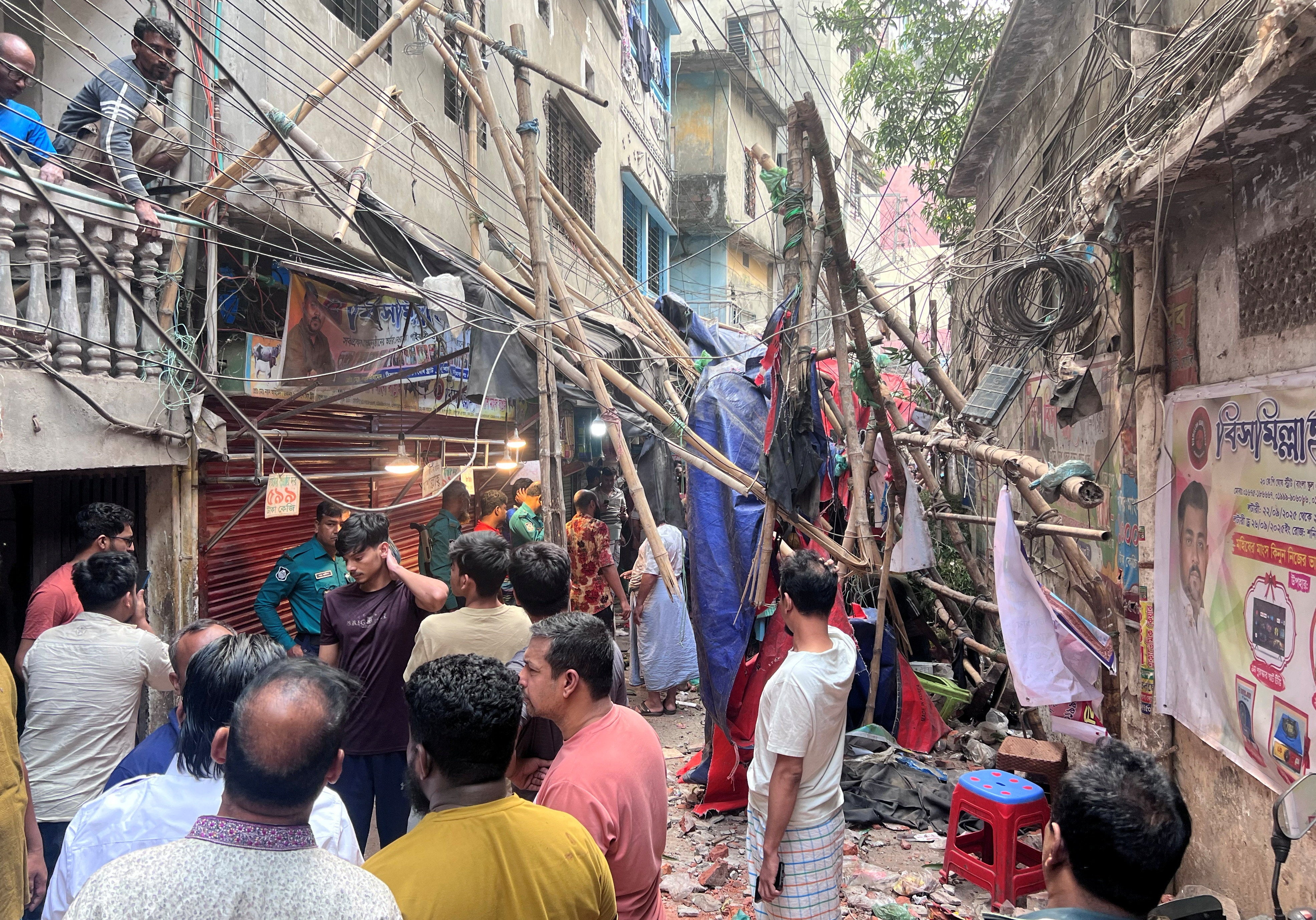<p>People stand in an alley after vacating their homes following an earthquake in Dhaka</p>