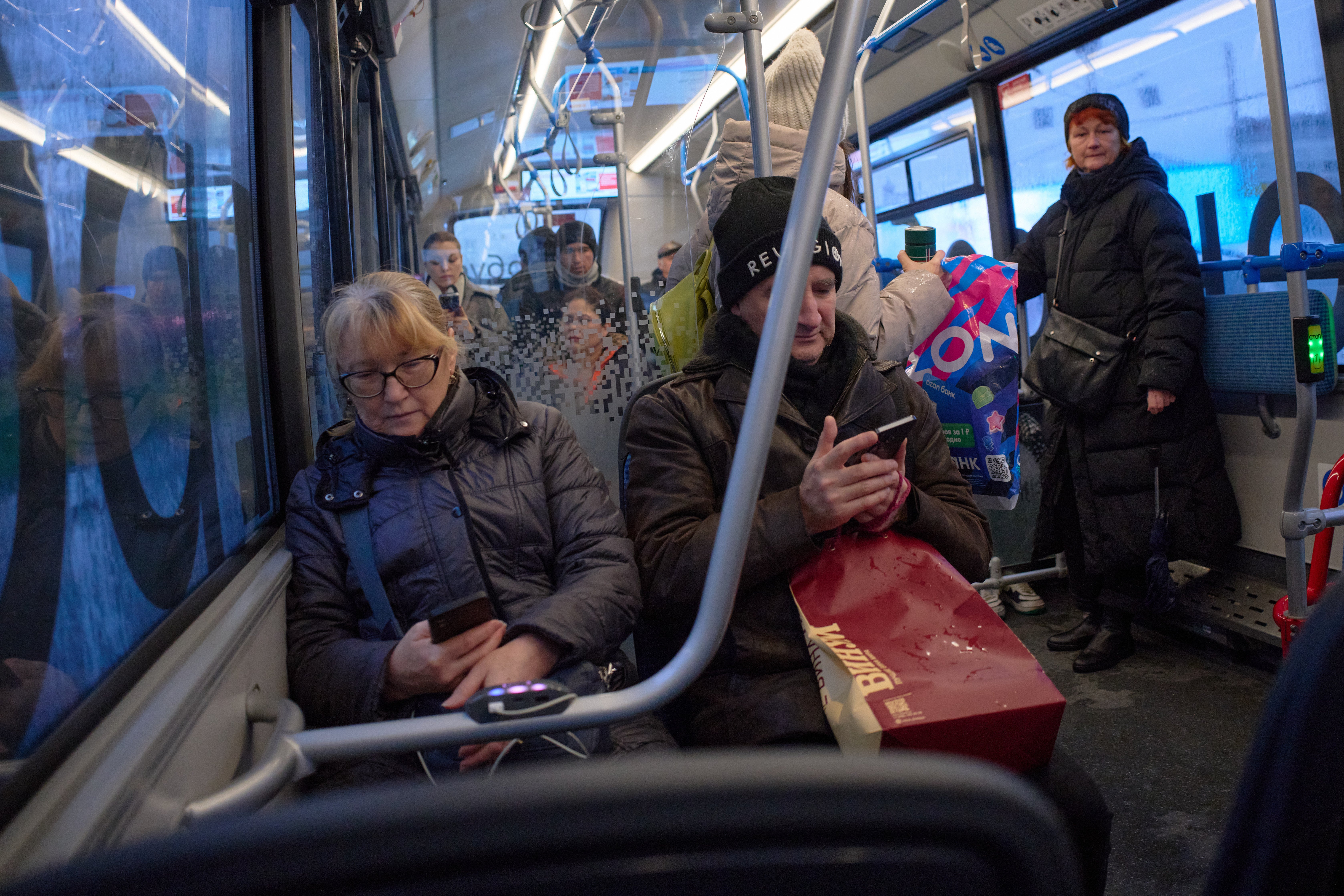 Passengers look at their smartphones on a bus in Moscow, Russia, Nov. 17, 2025. (AP Photo/Alexander Zemlianichenko, File)