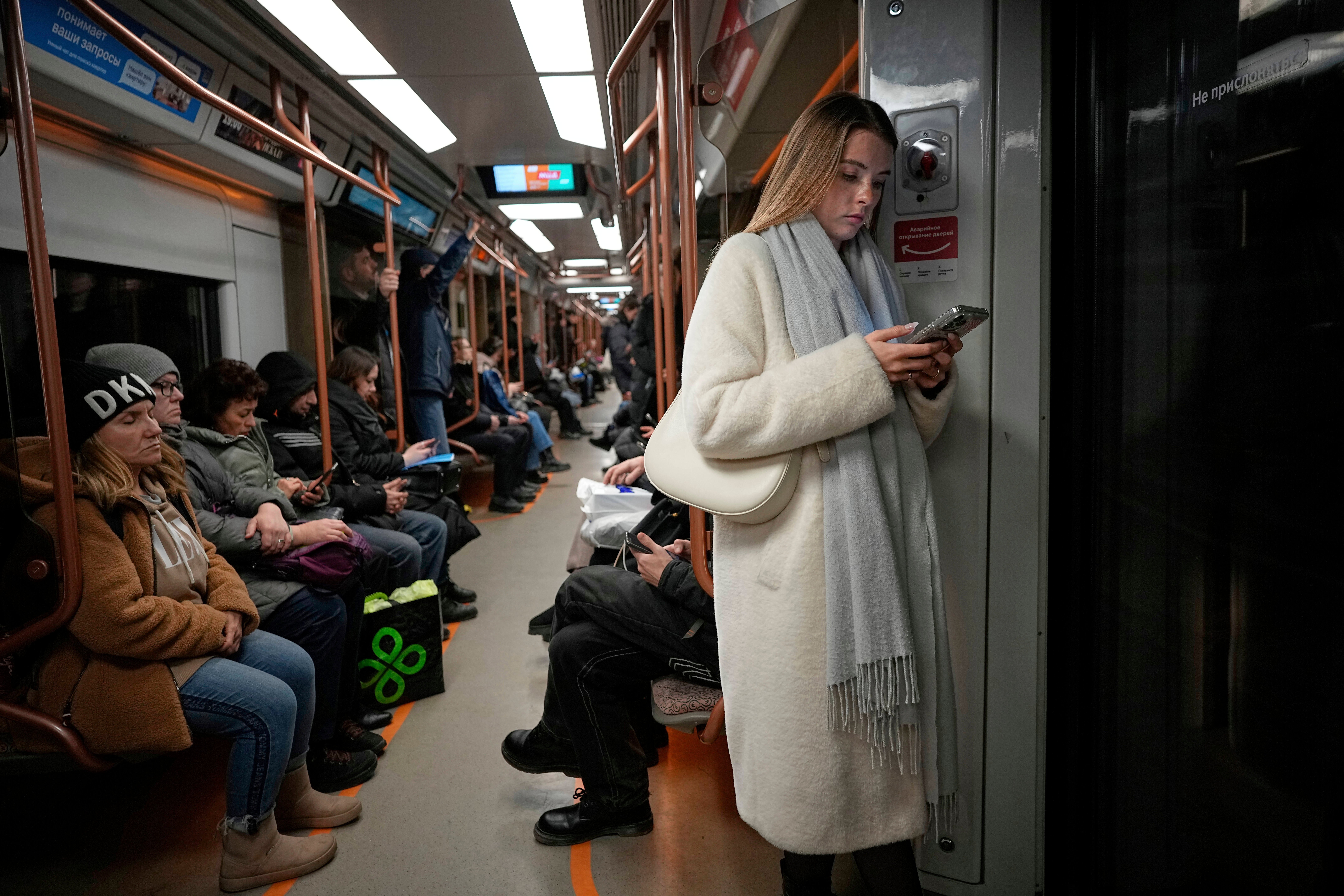 A woman looks at her smartphone on the subway in Moscow, Russia, March 4, 2025. (AP Photo/Alexander Zemlianichenko, File)