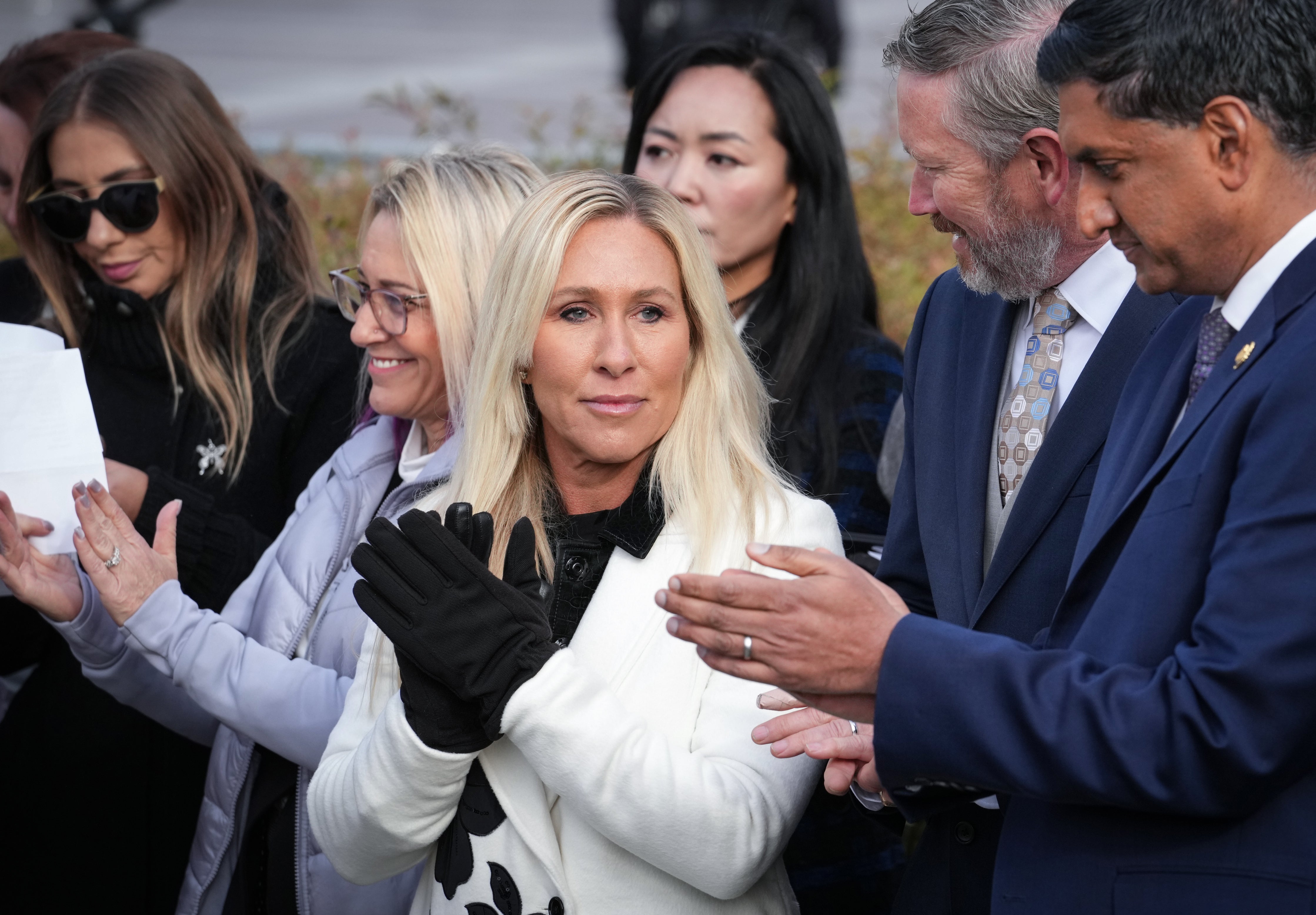 Rep. Marjorie Taylor-Greene, R-Ga., center, with Rep. Thomas Massie, R-Ky., second from right, and Rep. Ro Khanna, D-Calif., far right, applauds during a news conference as the House prepares to vote on the Epstein Files Transparency Act, at the Capitol in Washington, Tuesday, Nov. 18, 2025