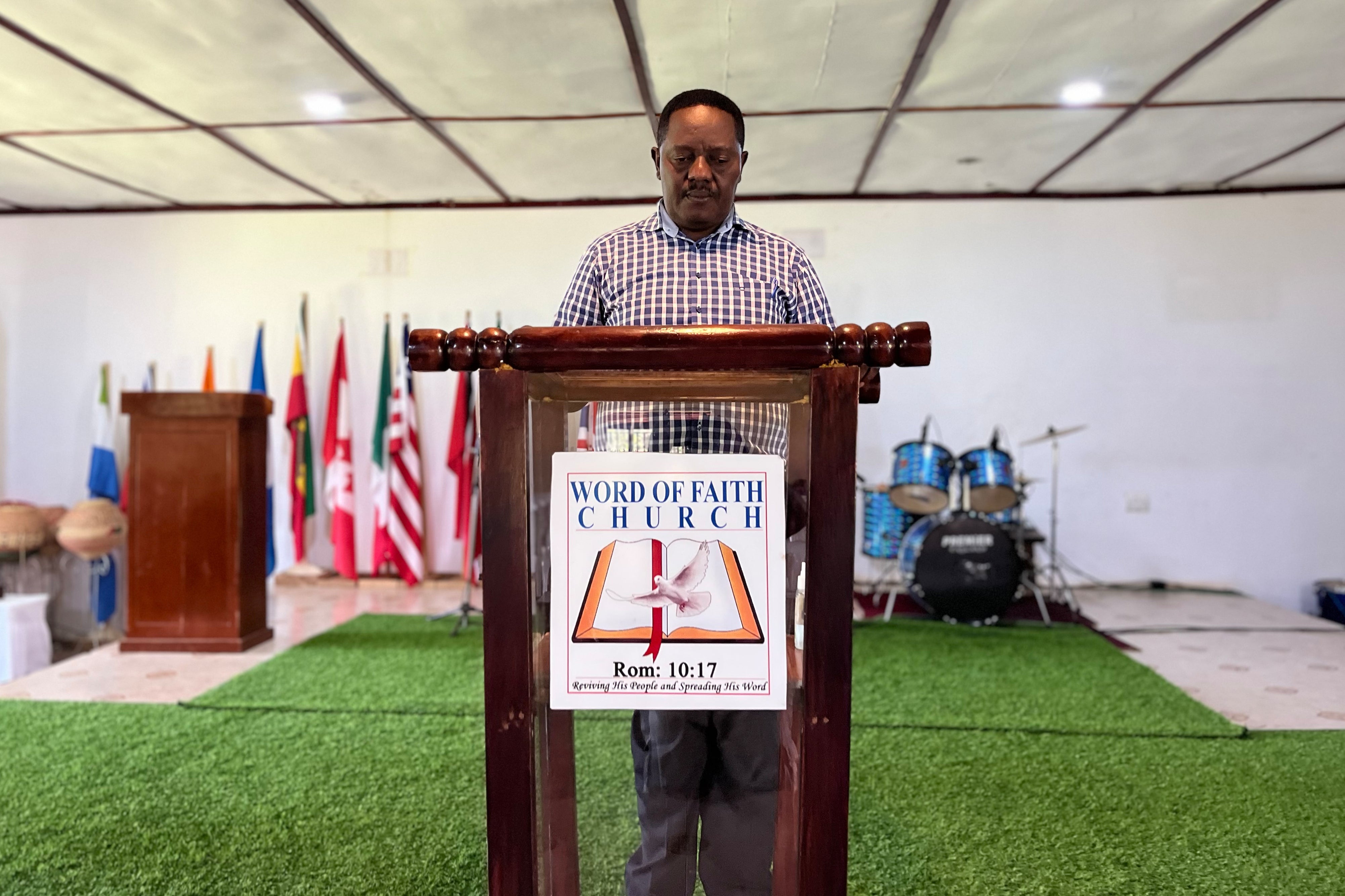 Andrew Mutengu, a counselor and pastor of Word of Faith Ministries, stands at the pulpit of his Pentecostal church in Mbale, Uganda