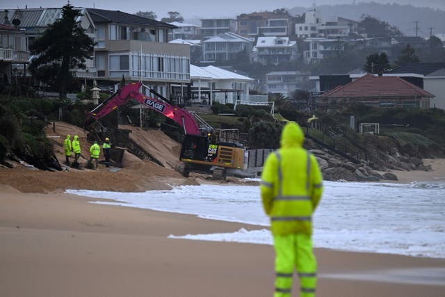 <p>Representative: Workers operate heavy machinery to stabilise a beach in Australia, forcing residents to evacuate beachfront homes </p>