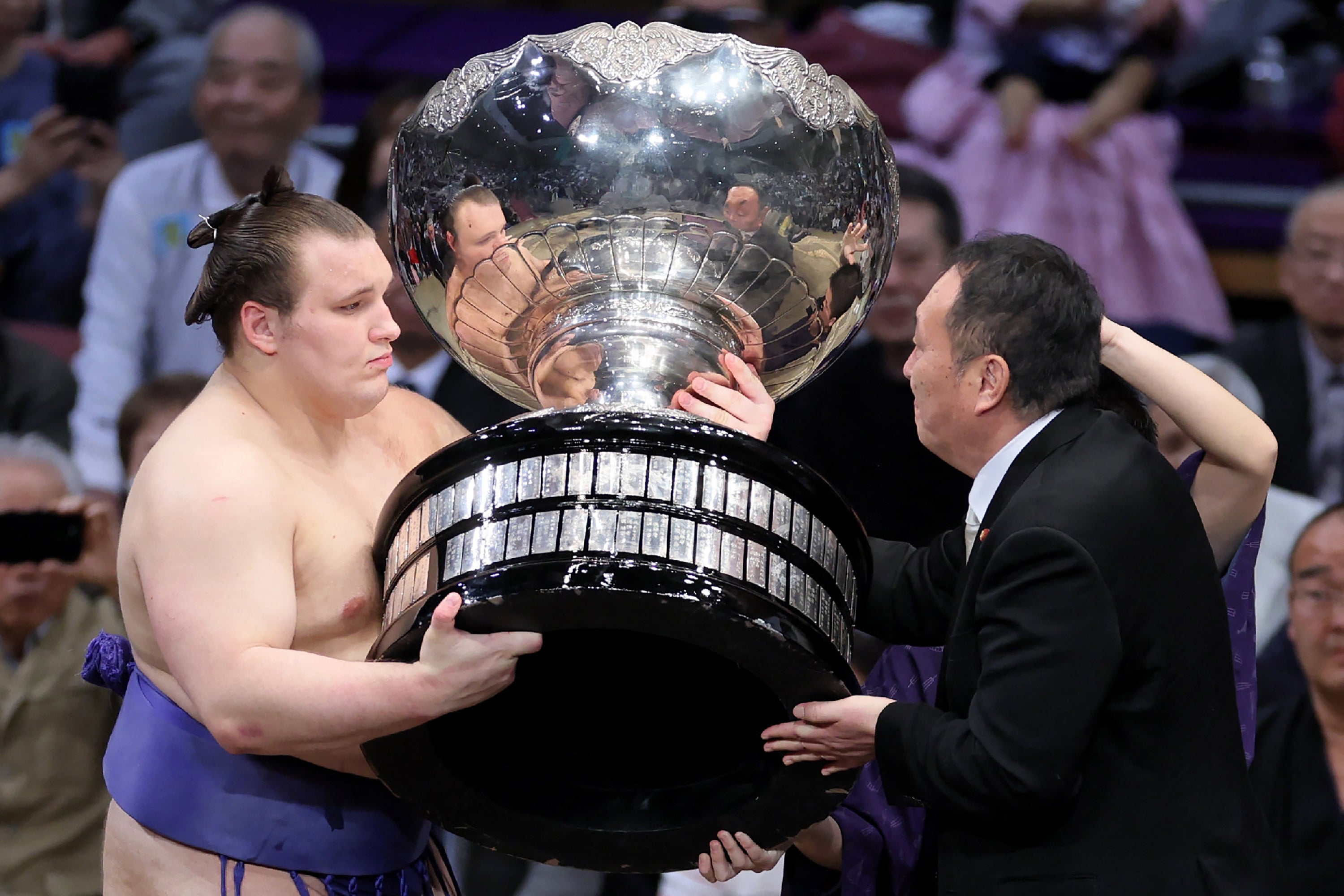 <p>Ukrainian sumo wrestler Danylo Yavhusishyn, also known by his Japanese ring name Aonishiki Arata (L), receives the Prime Minister's Cup trophy after winning the Grand Sumo Tournament in Fukuoka on November 23, 2025</p>