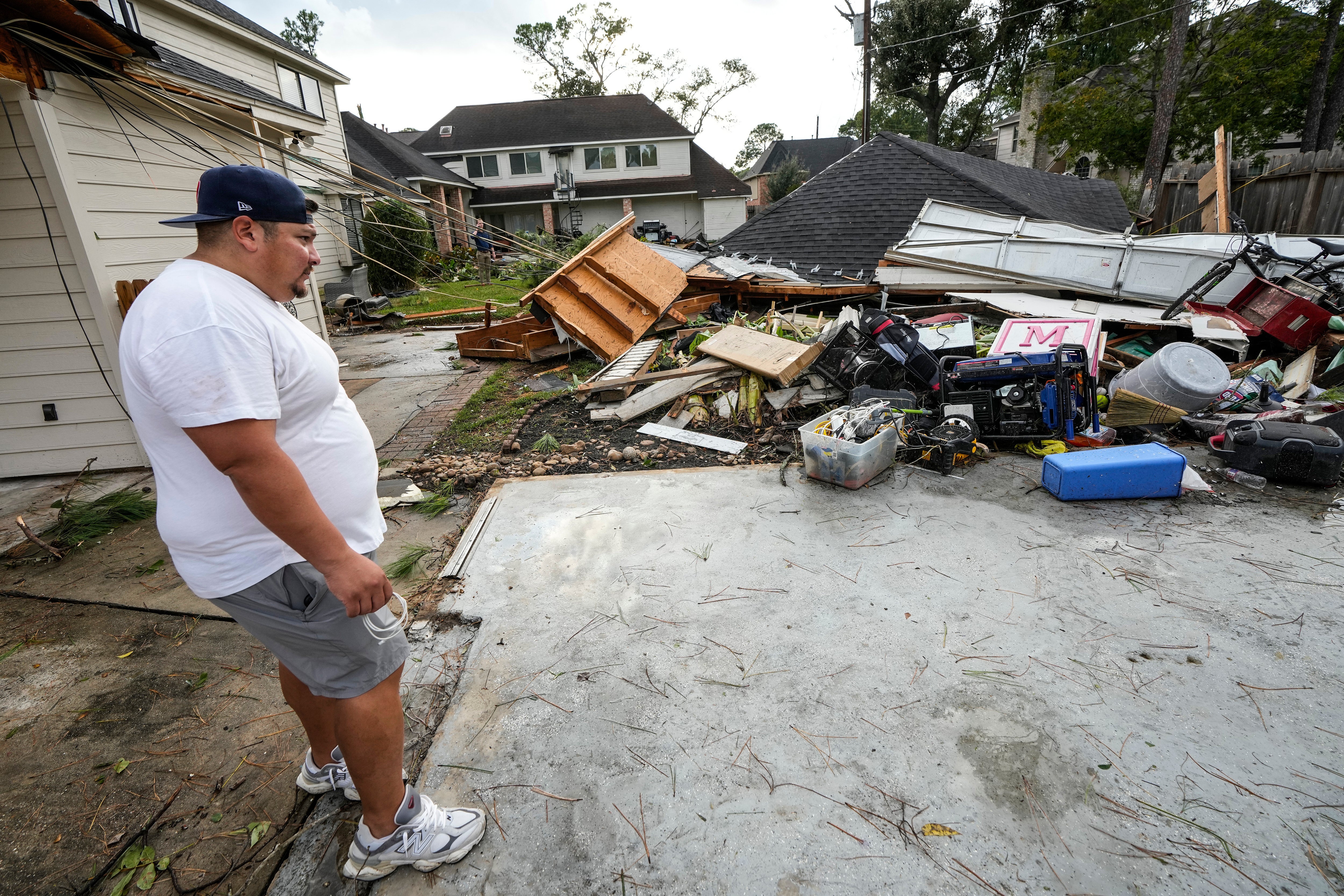 Guillermo Vargas surveys damage to his home, where his garage was swept off its foundation, while cleaning up storm damage after severe weather hit in the Memorial Northwest subdivision, in Spring, Texas, Monday, Nov. 24, 2025