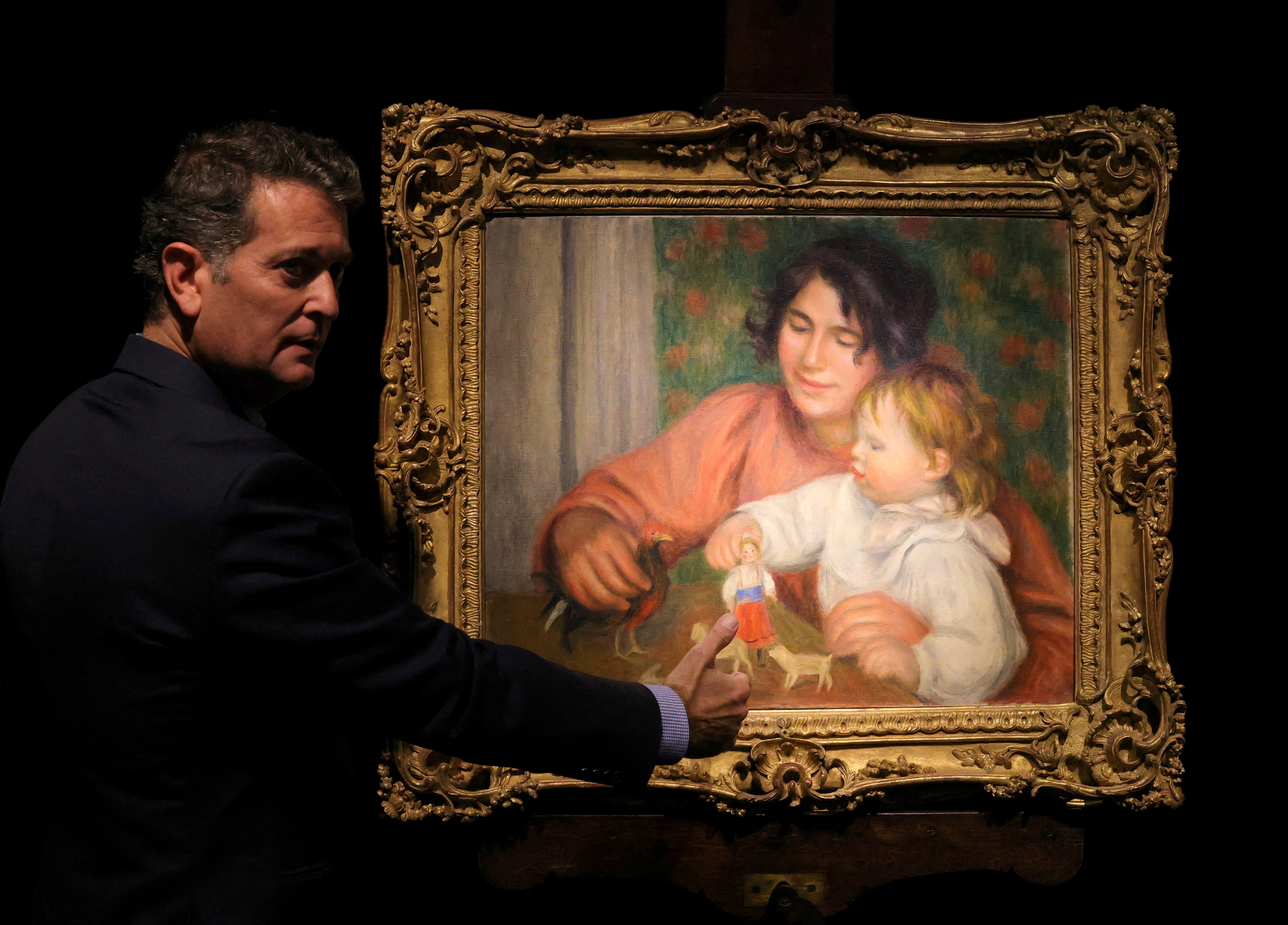 Art consultant Pascal Perrin stands next to the painting "L'enfant et ses jouets - Gabrielle et le fils de l'artiste, Jean" (Child with Toys - Gabrielle and the Artist's Son, Jean), before 1910, by artist Pierre-Auguste Renoir (1841-1919) on display before its auction at Drouot auction house in Paris, France
