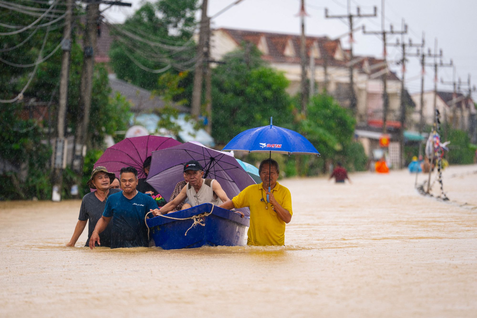 <p>People wade through flood waters with residents being evacuated on a boat in Hat Yai in Thailand's southern Songkhla province </p>