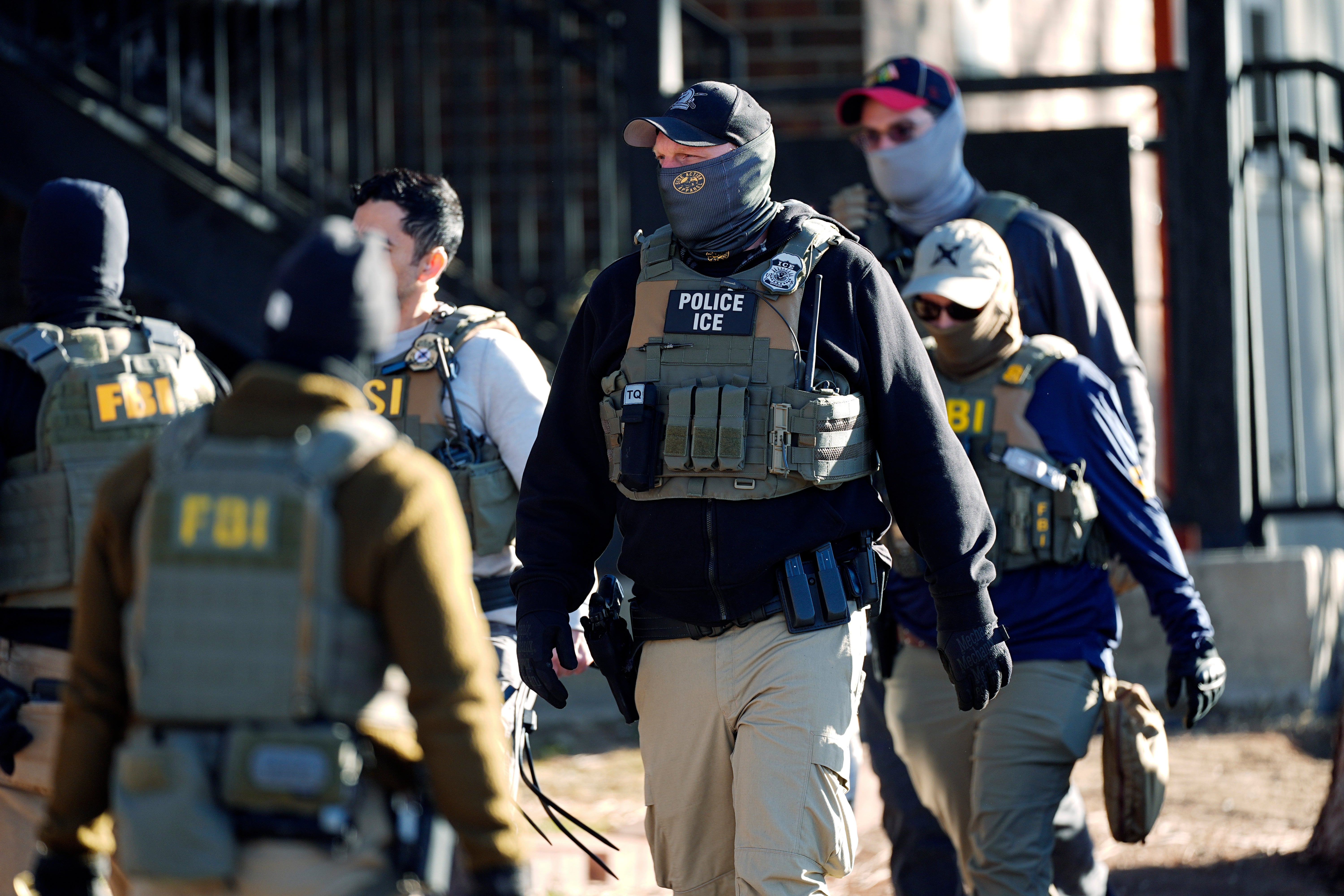 Masked federal agents spread out through an apartment complex during a raid, February 5, 2025, in east Denver.
