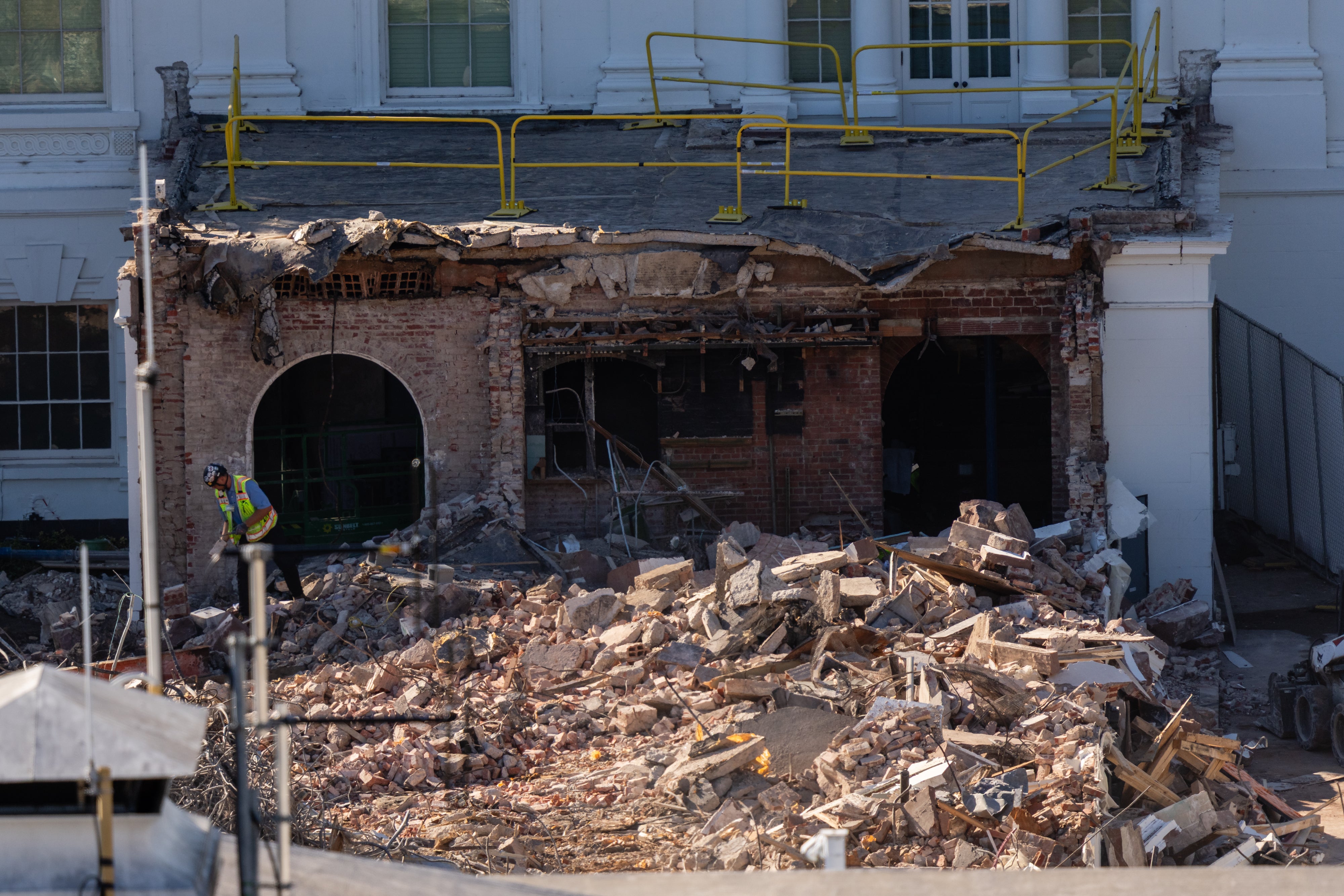 A worker clears rubble after the East Wing of the White House was demolished.