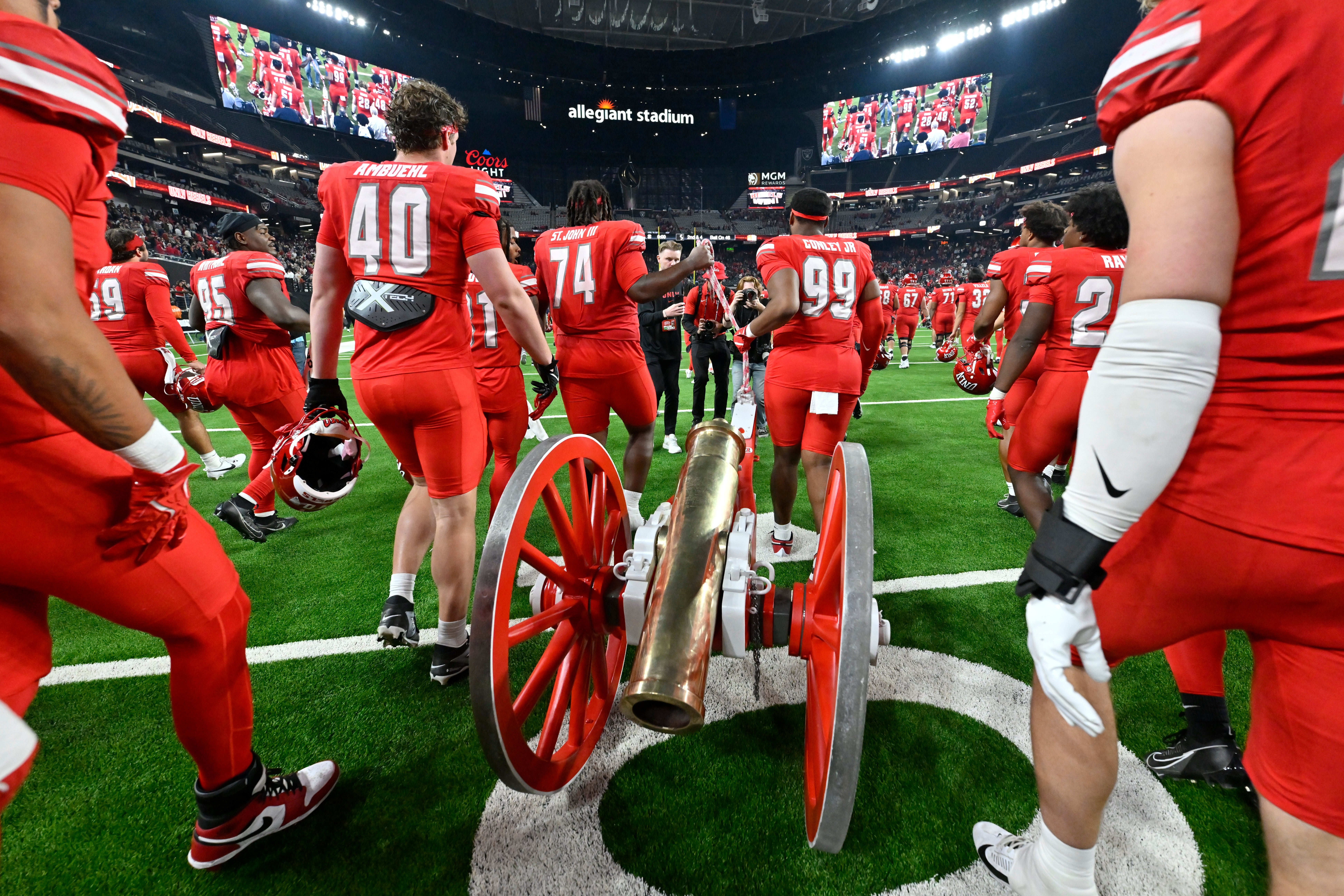 UNLV pulls the Fremont Cannon trophy, awarded to the winner of the annual Battle of Nevada game, on the field after defeating Nevada in an NCAA college football game Saturday, Nov. 30, 2024, in Las Vegas