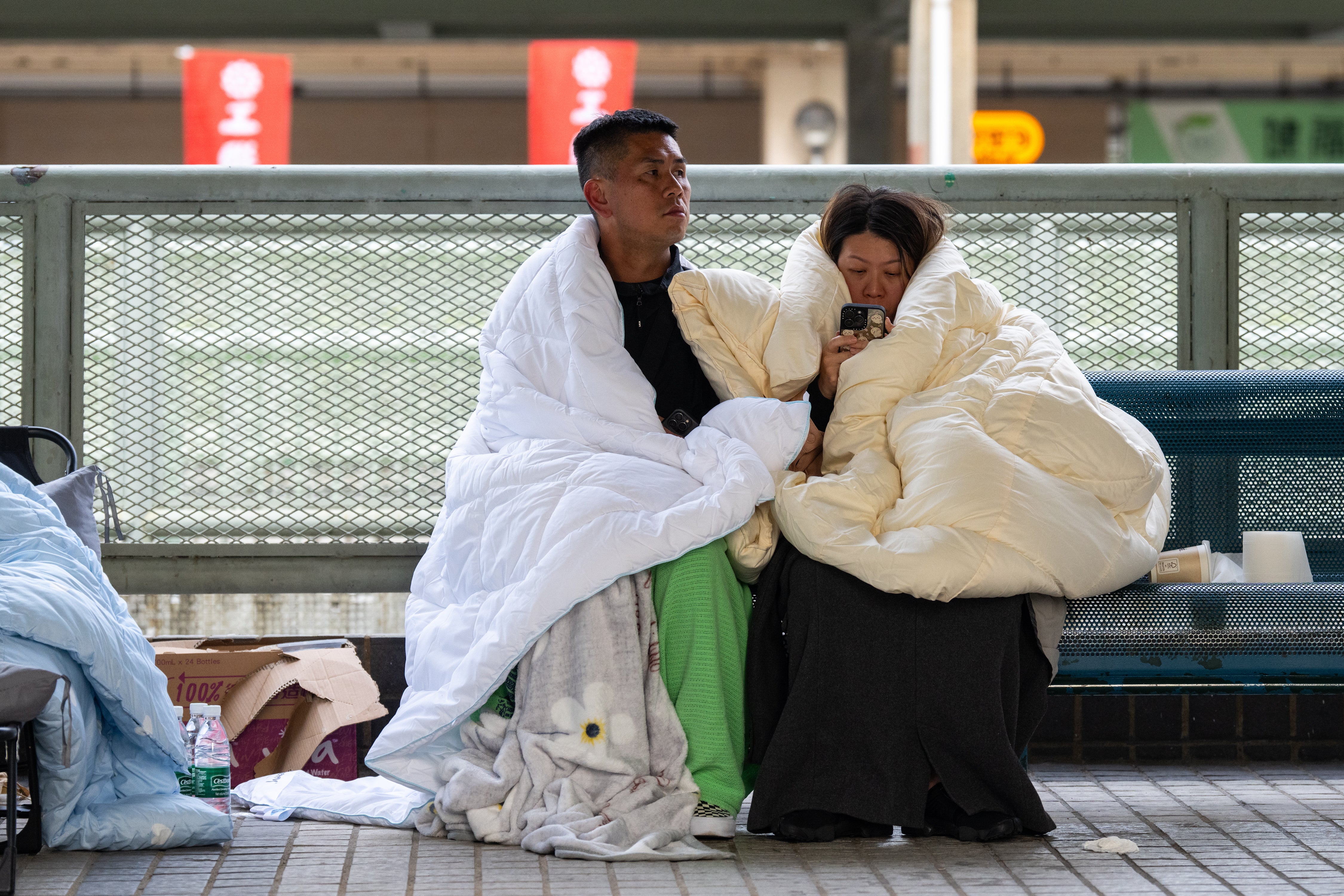 Residents rest at the scene of the fire at Wang Fuk Court on Thursday