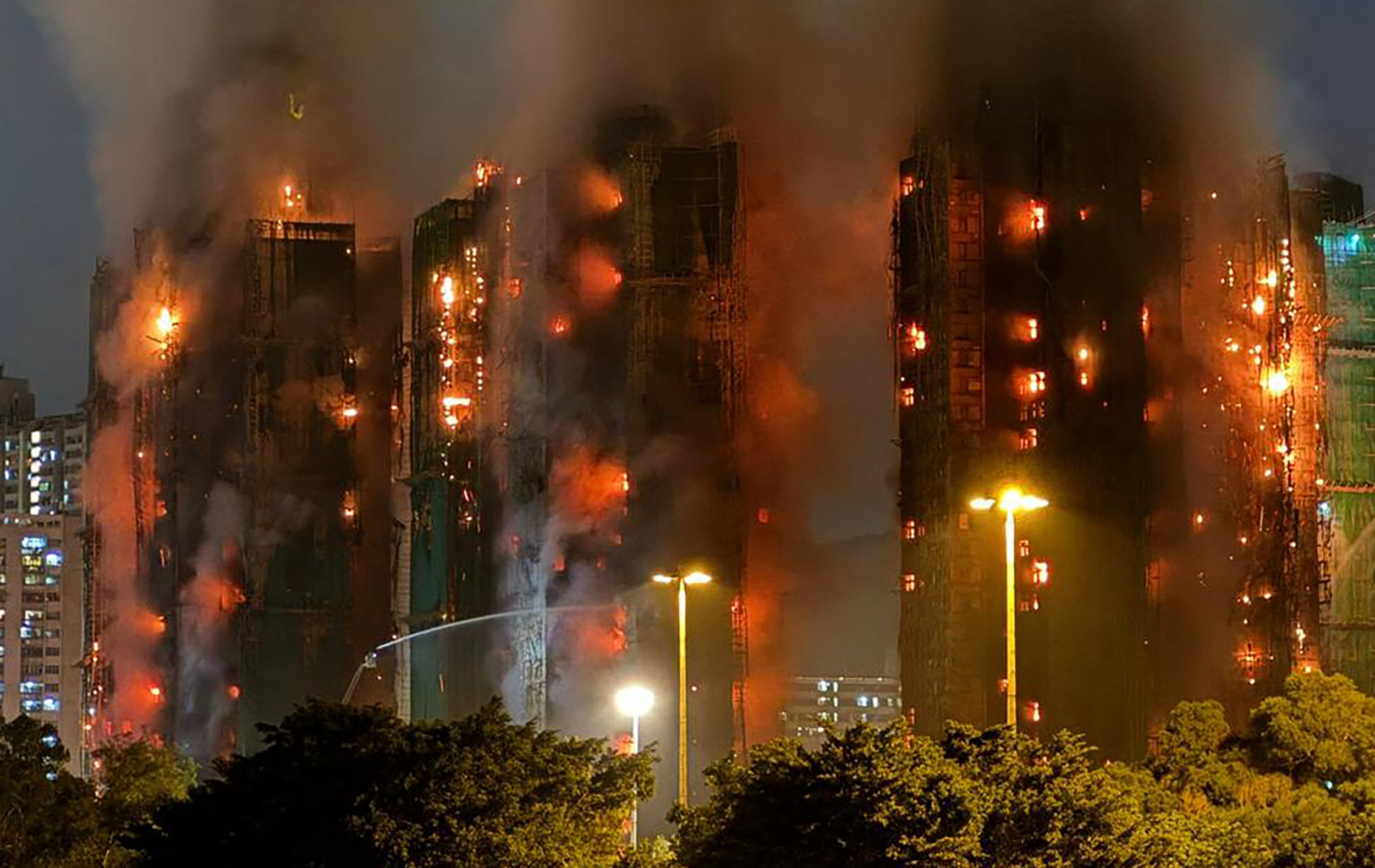 <p>Thick smoke and flames rise as a fire engulfs several apartment blocks at the Wang Fuk Court estate in Hong Kong's Tai Po district on 26 November 2025</p>