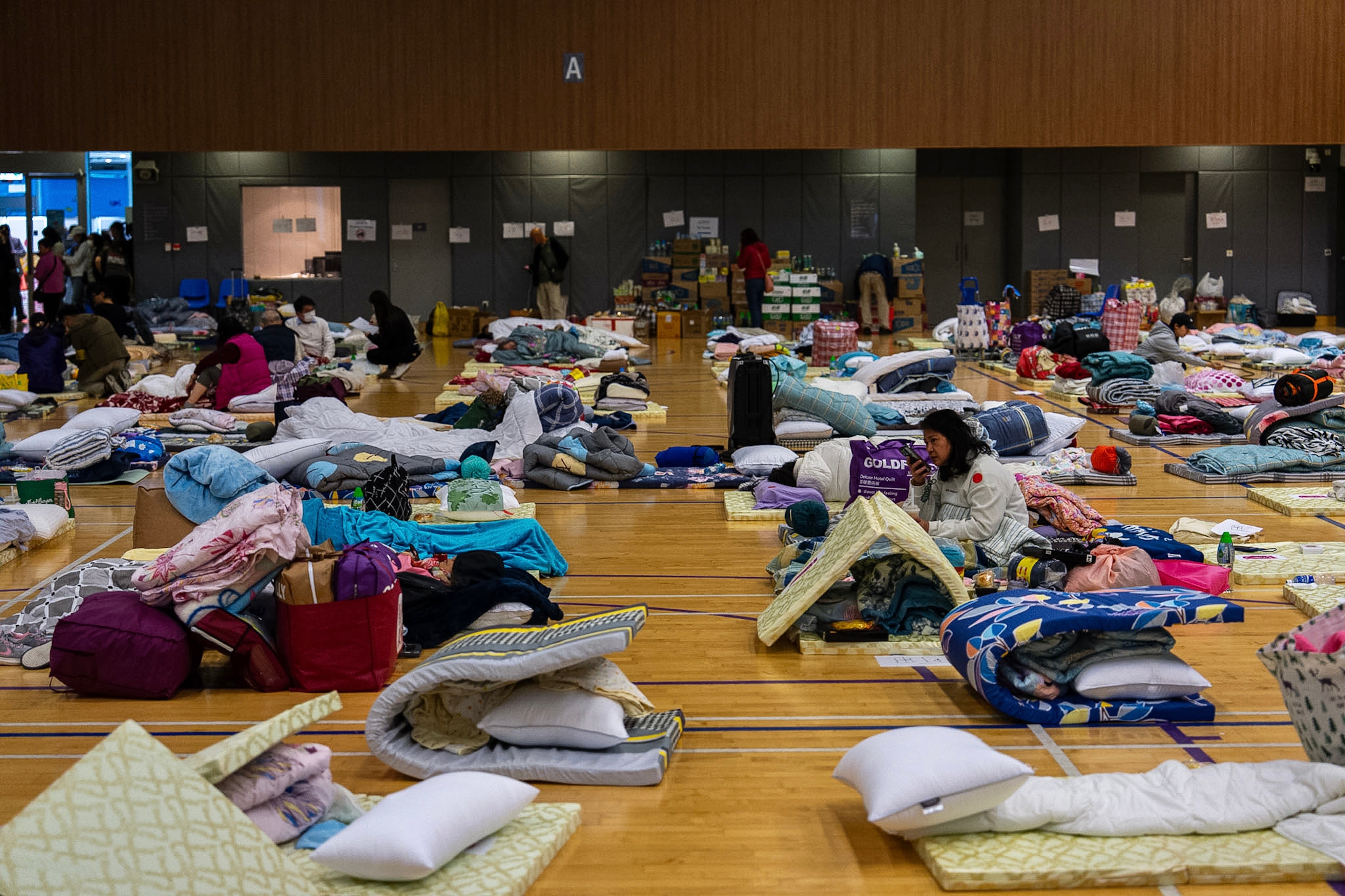 Residents rest at a temporary shelter near the fire scene at Wang Fuk Court