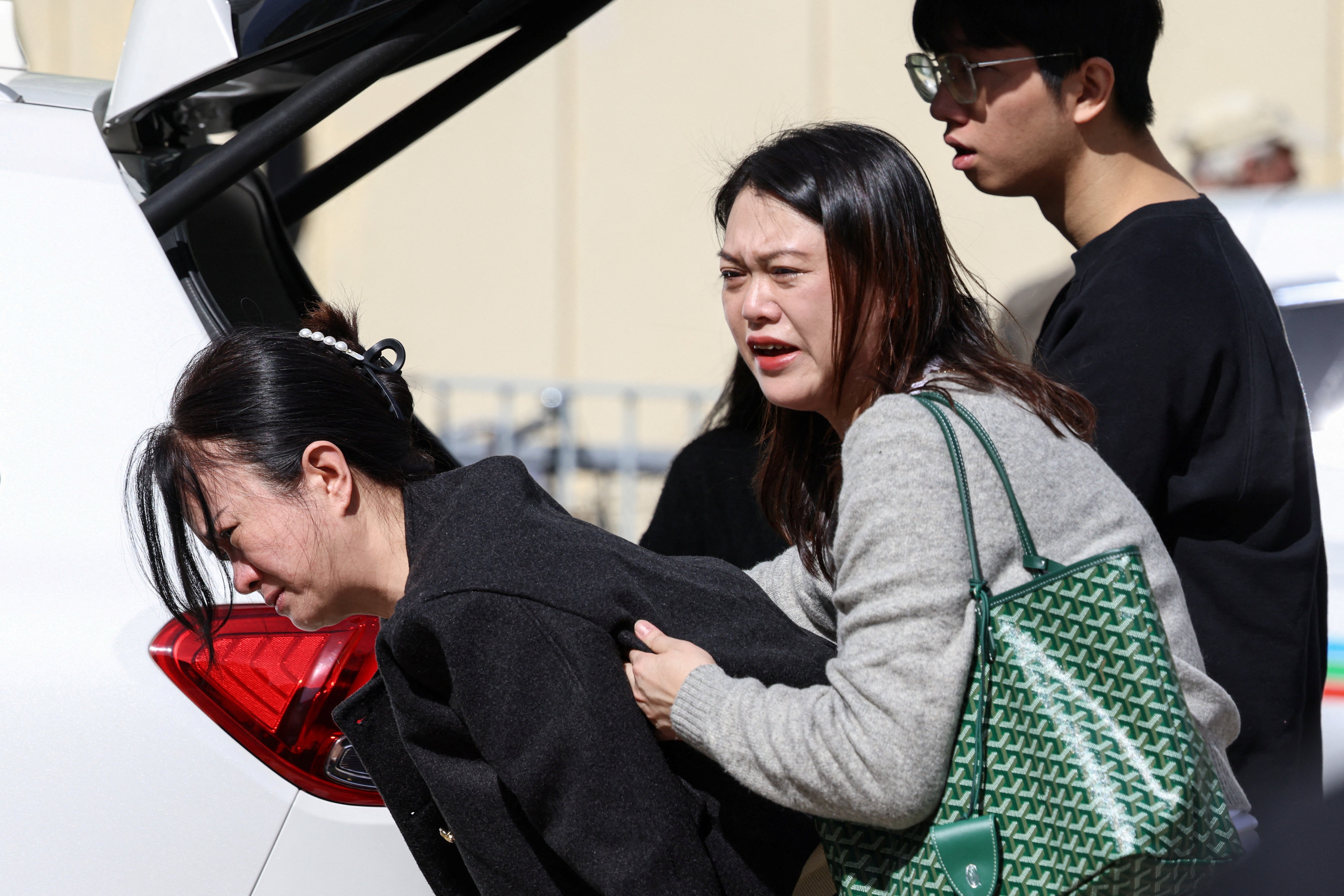 A woman reacts after learning her pet died in the Wang Fuk Court housing estate fire in Tai Po