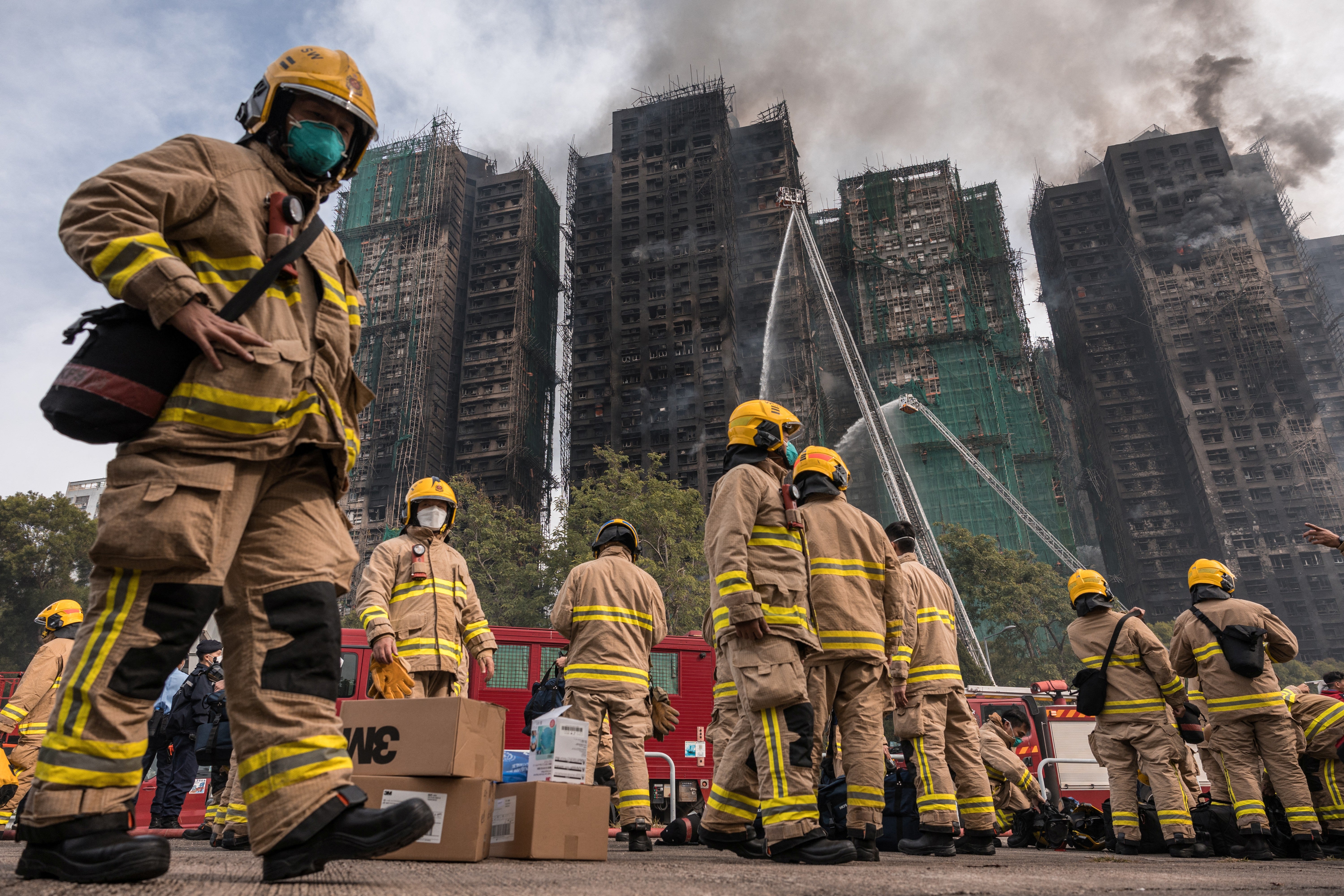 Firemen get ready after a major fire swept through several apartment blocks at the Wang Fuk Court residential estate in Hong Kong's Tai Po district