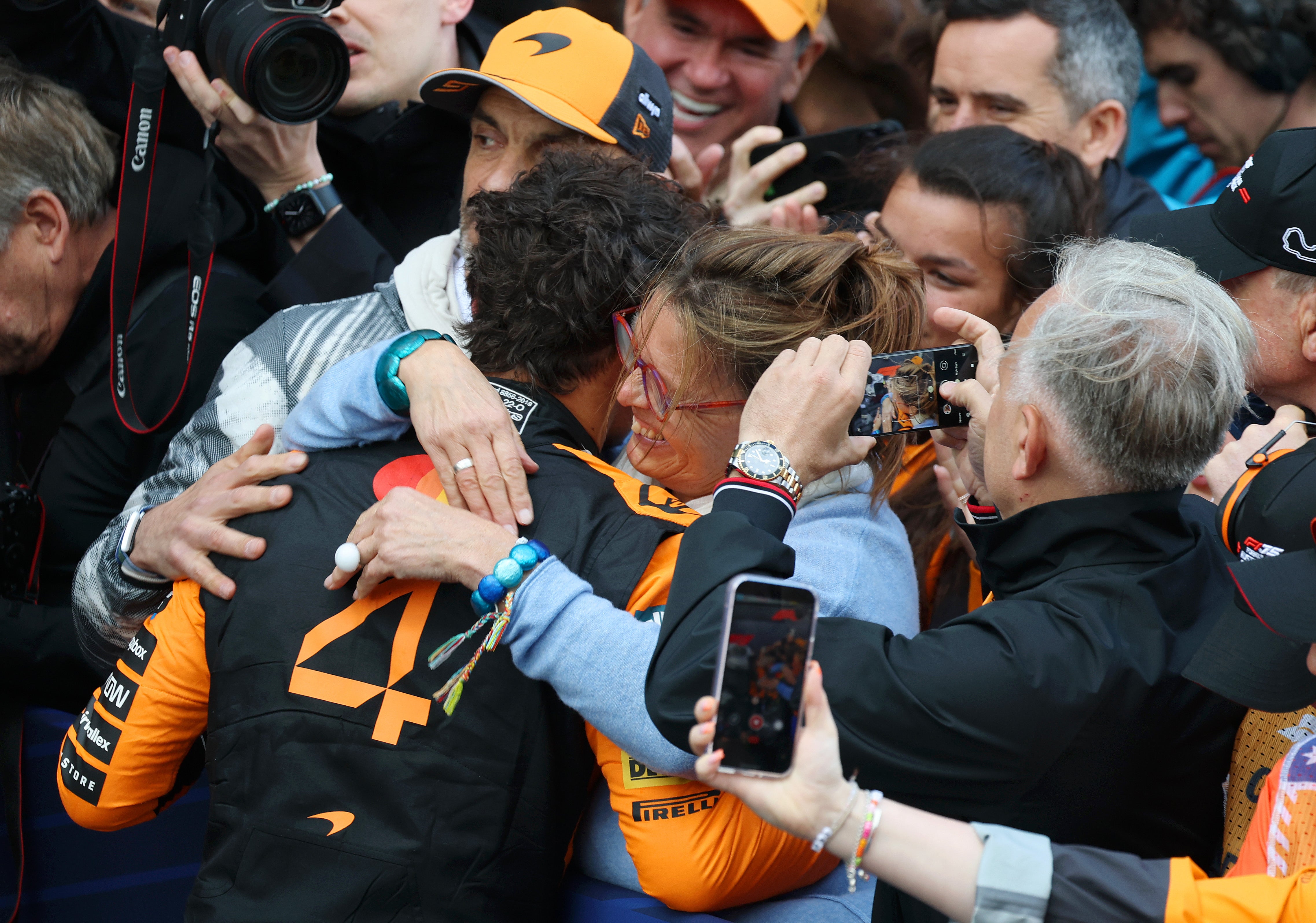 Norris hugs his mother, Cisca, and father, Adam, after a win this year