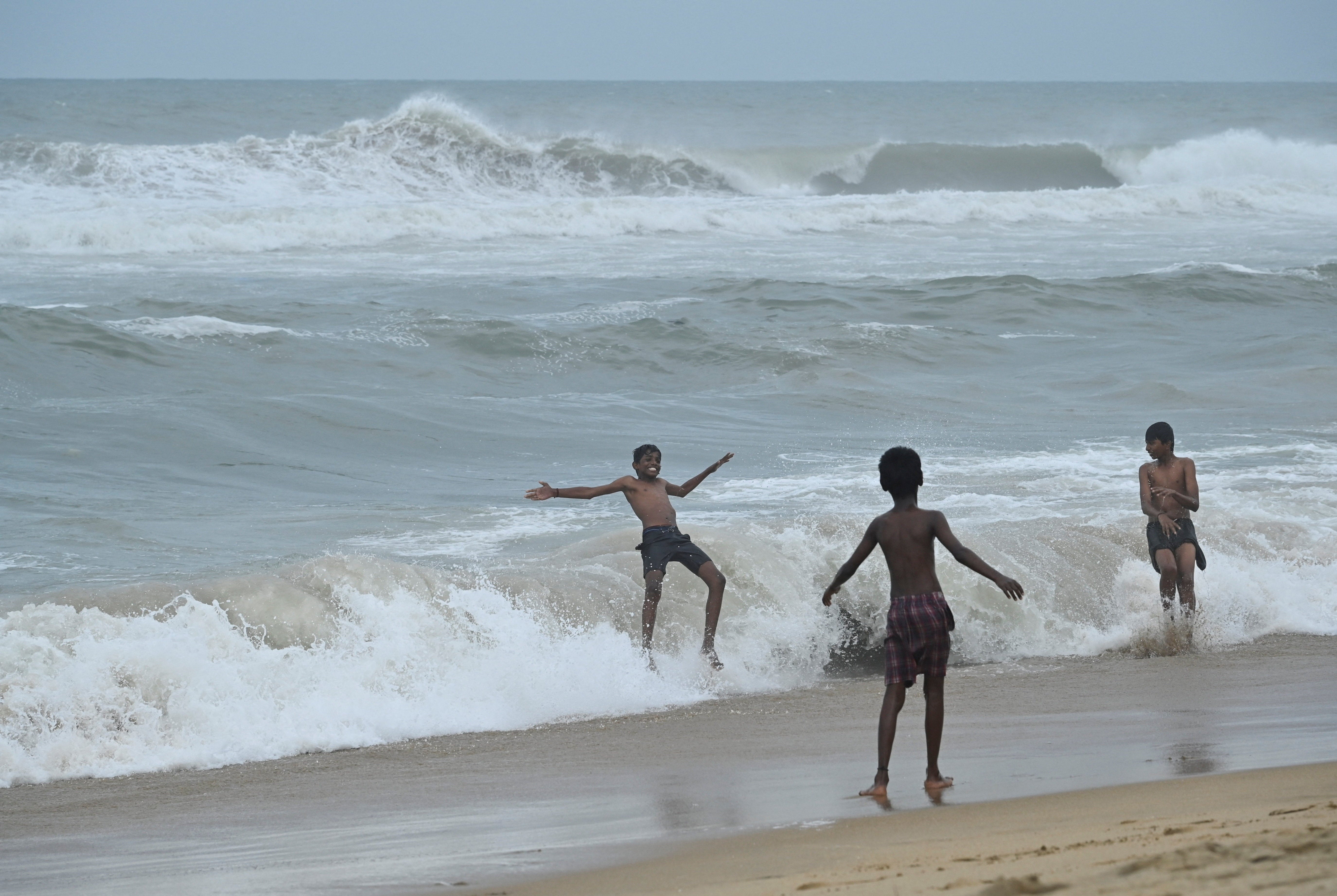 Children play at the beach ahead of Cyclone Ditwah in Chennai, India, November