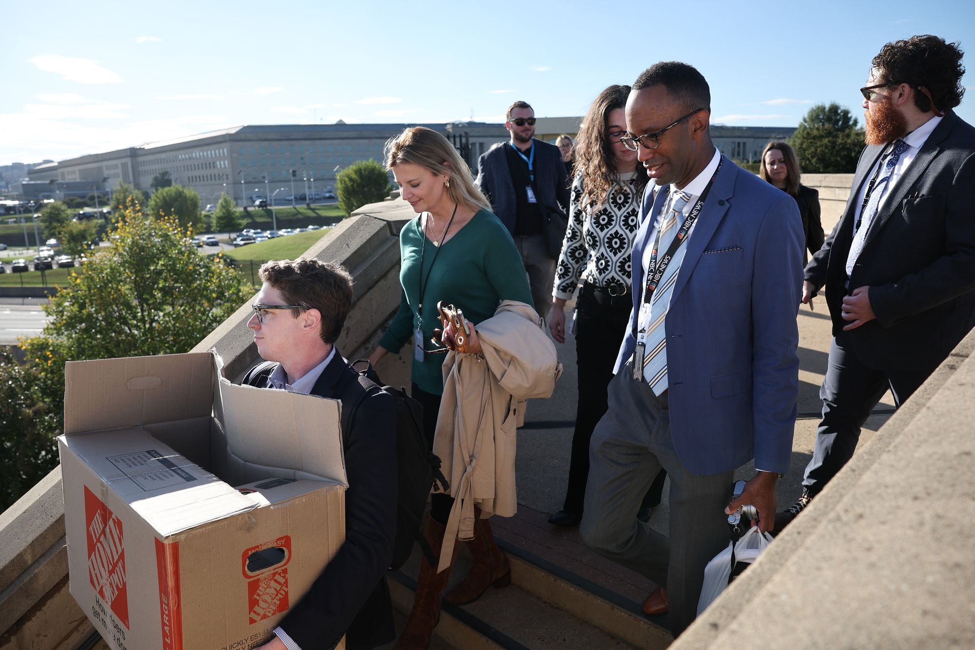 Pentagon reporters walk out of the building carrying their belongings after turning in their press badges October 15, 2025 in Arlington, Virginia. Reporters from nearly every major news organization opted to turn in their press passes rather than sign new rules viewed as an infringement on First Amendment rights