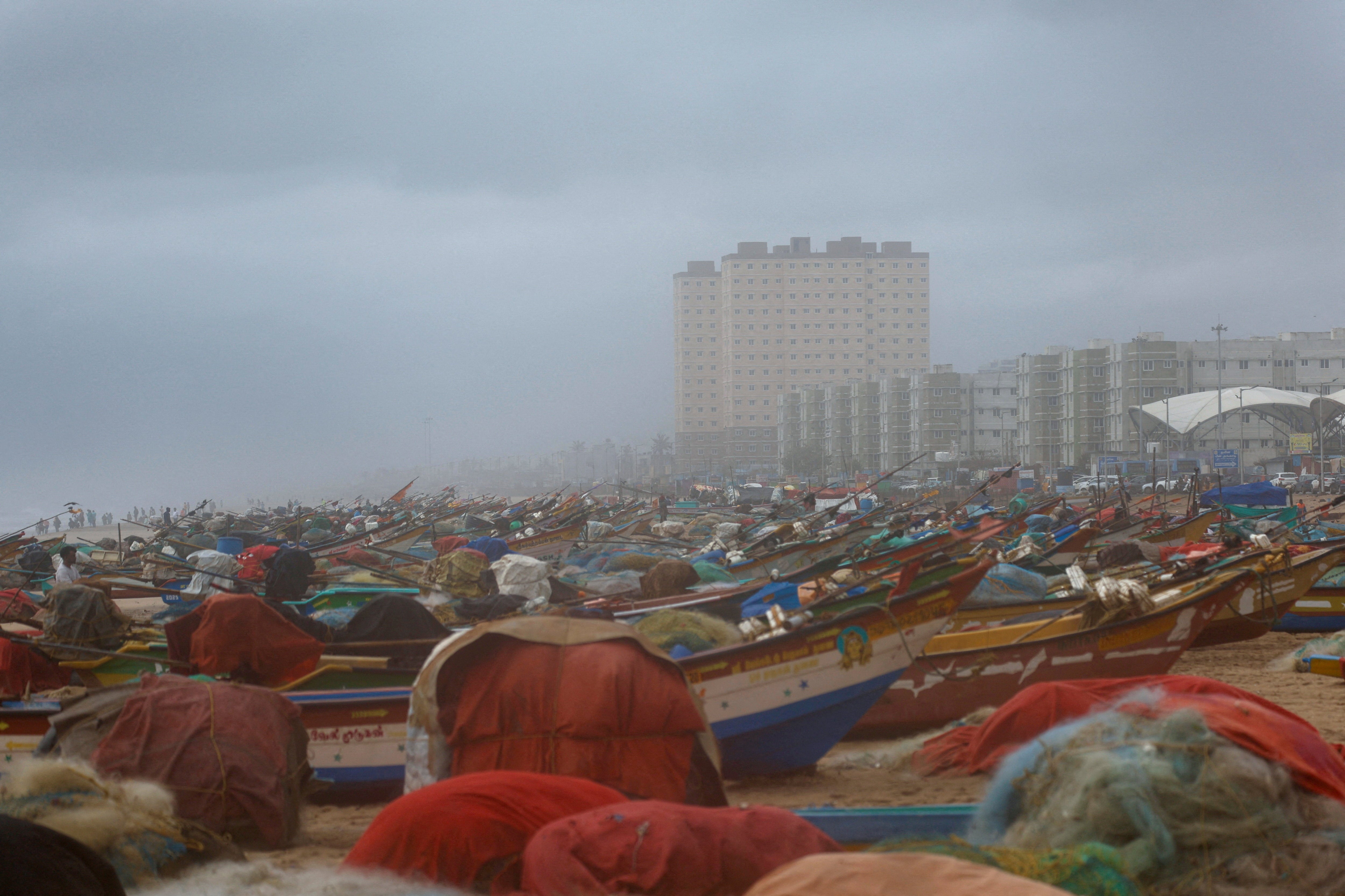 A man stands amid fishing boats onshore ahead of Cyclone Ditwah’s arrival in Chennai, India, on 30 November 2025