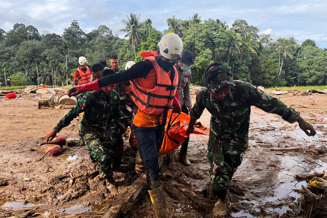 Rescuers take a survivor out of floodwaters in Aceh, Indonesia