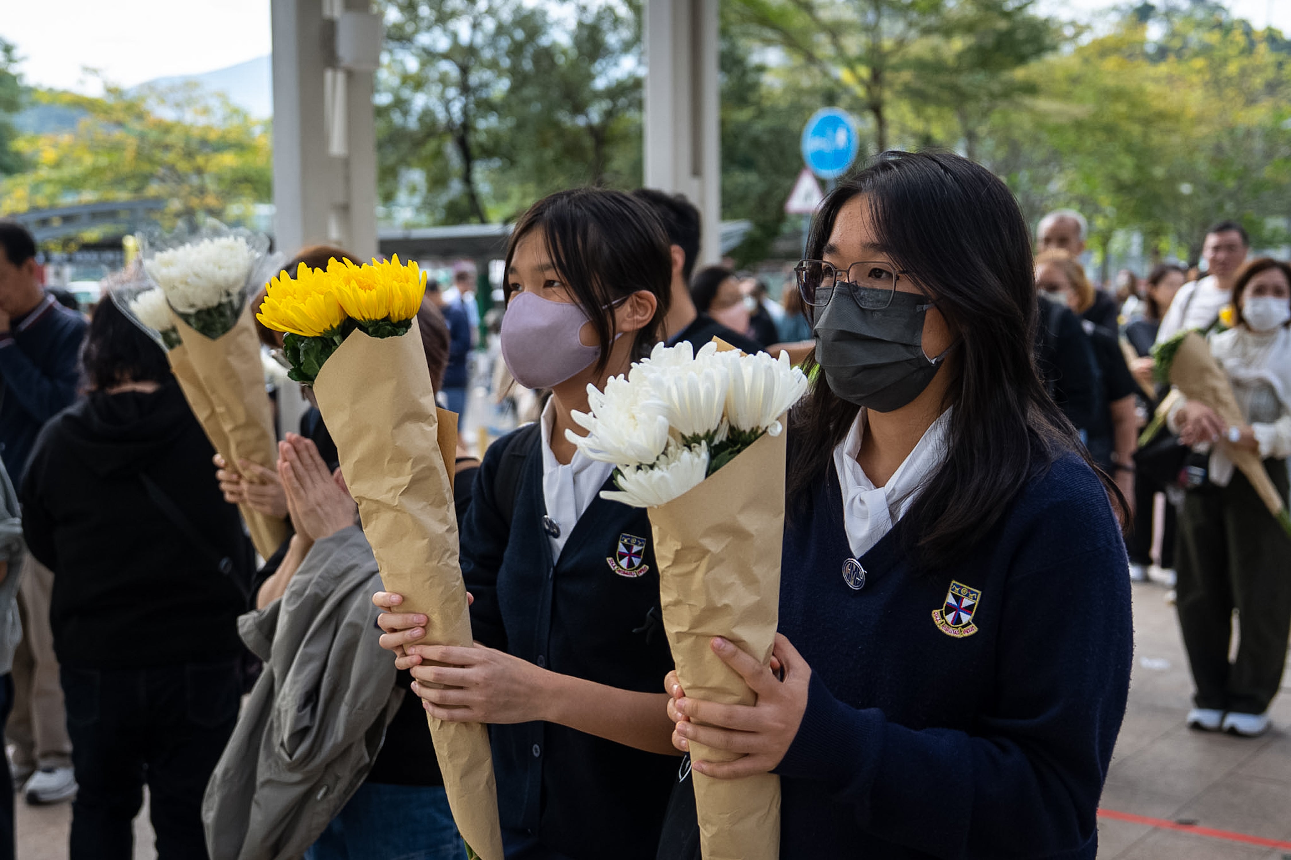 People offer flowers for the victims of the Wang Fuk Court fire in Hong Kong on 1 December 2025