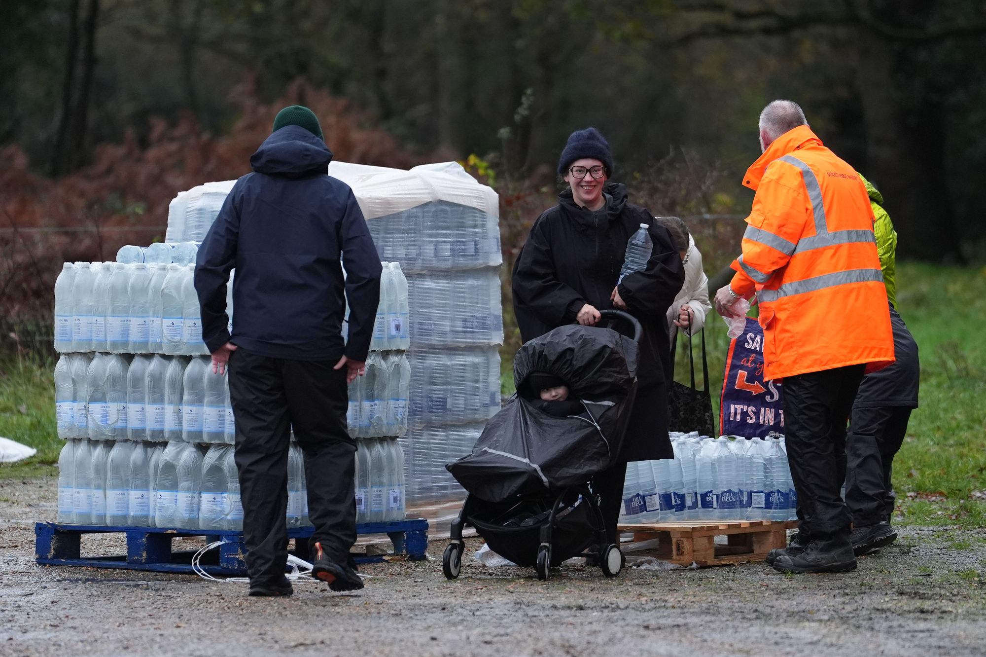 Residents collect bottled water. As many as 23,000 homes and premises have been without it
