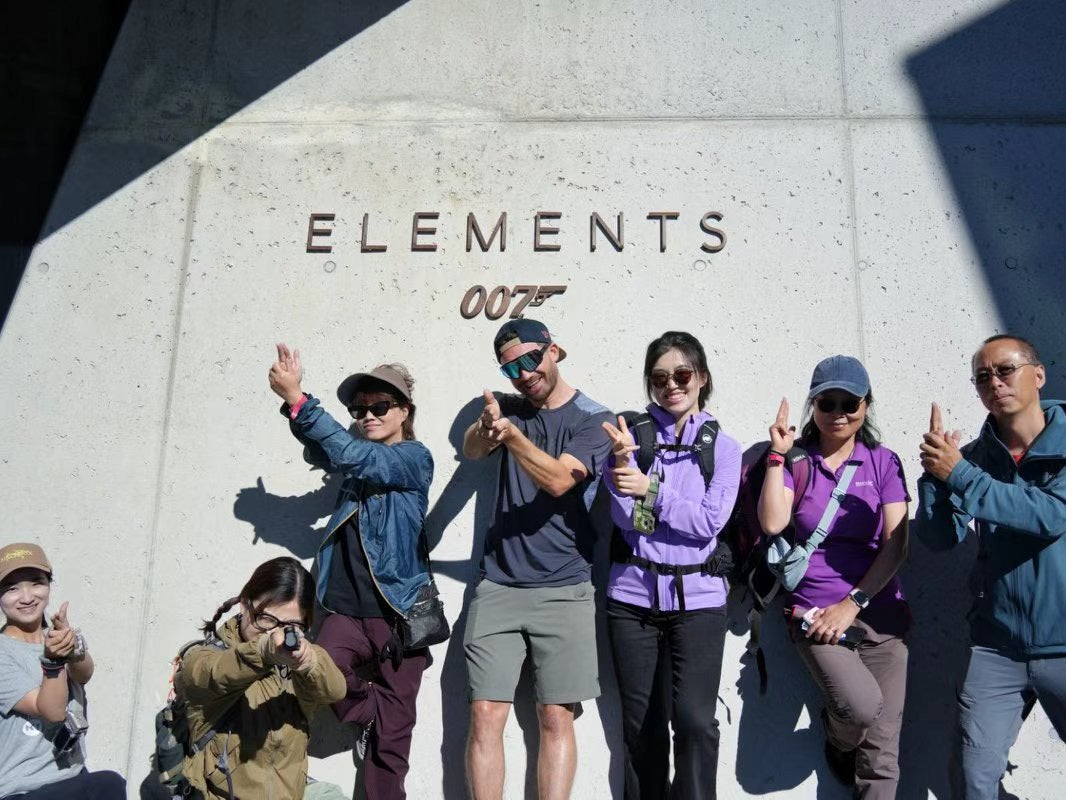 <p>Chinese influencers strike a James Bond pose outside the 007 Elements museum in Solden, Tyrol, Austria in July</p>