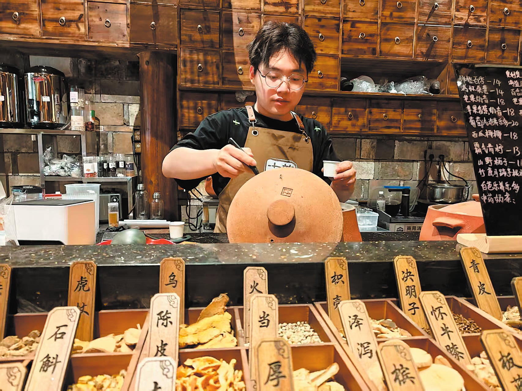 Gao Lingxu tends to simmering pots of traditional Chinese medicine tea at his shop in Nanping, Fujian province