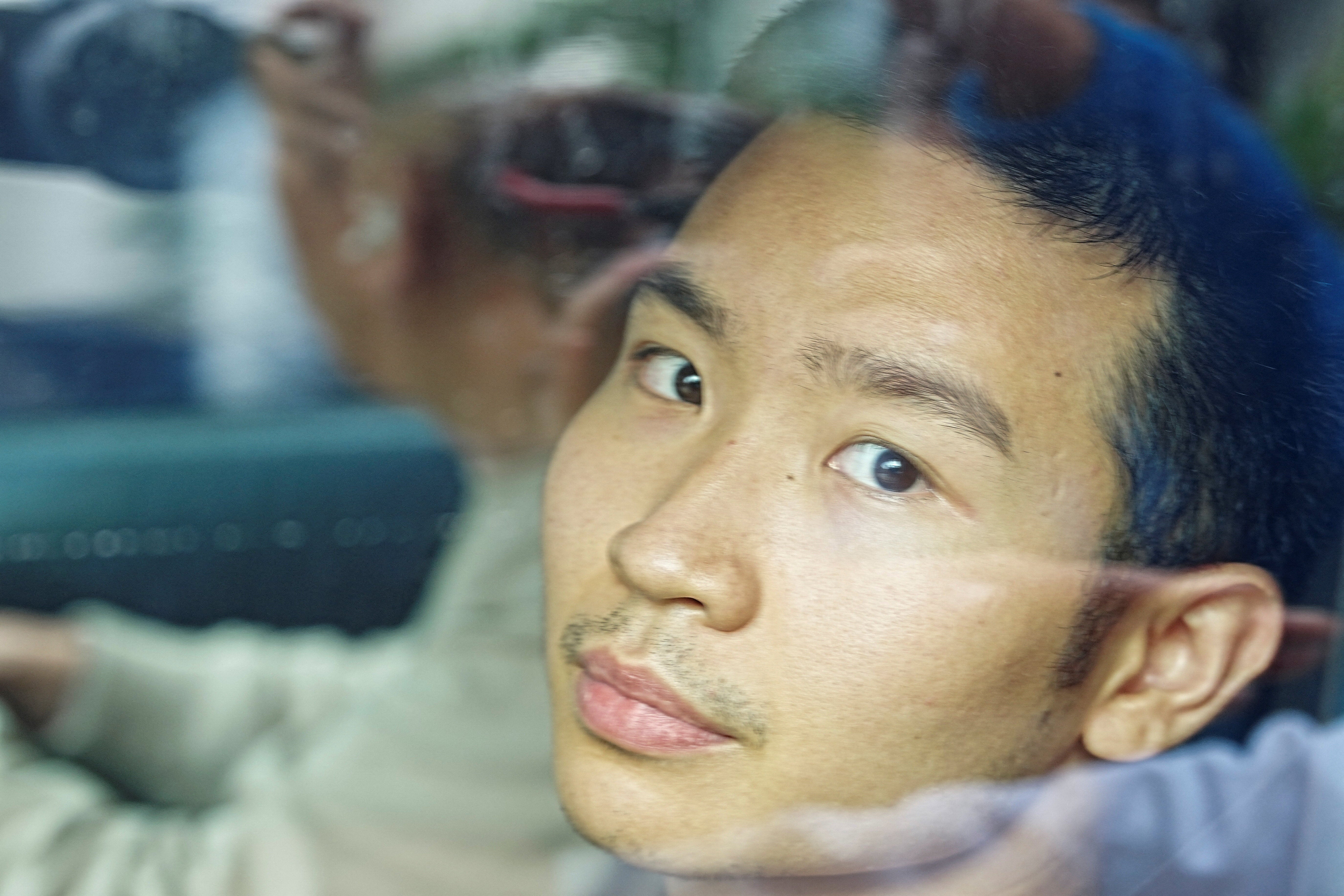 Hong Kong student Miles Kwan, 24, who was part of a group that launched a petition seeking an independent investigation into possible corruption and review of construction oversight after the Wang Fuk Court complex fire, leaves a police station in Hong Kong