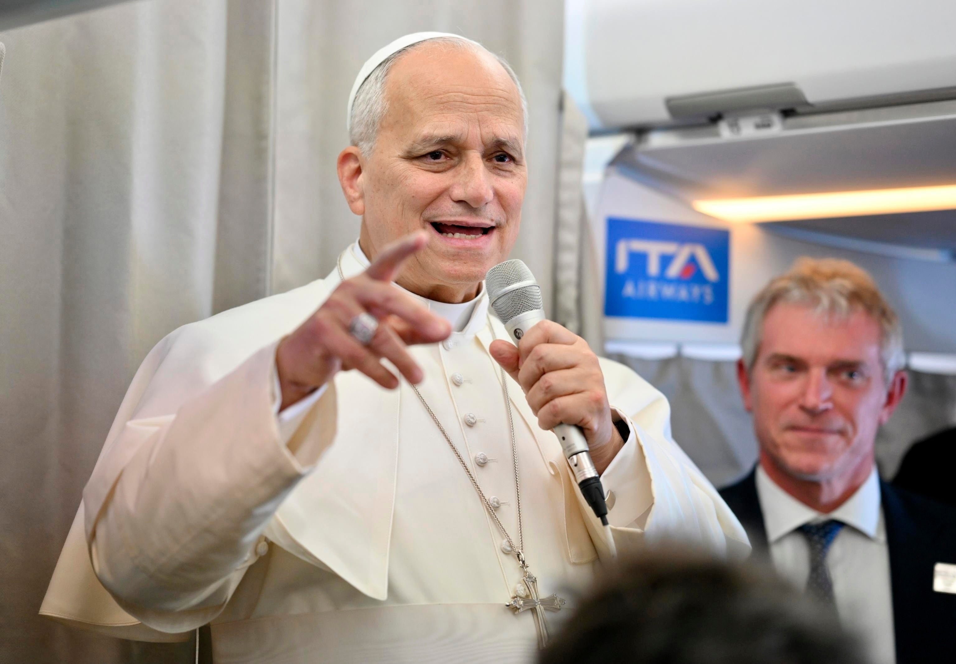 Pope Leo XIV talks to reporters aboard an airplane as he returns from a six-day visit to Turkey and Lebanon, Tuesday, Dec. 2, 2025