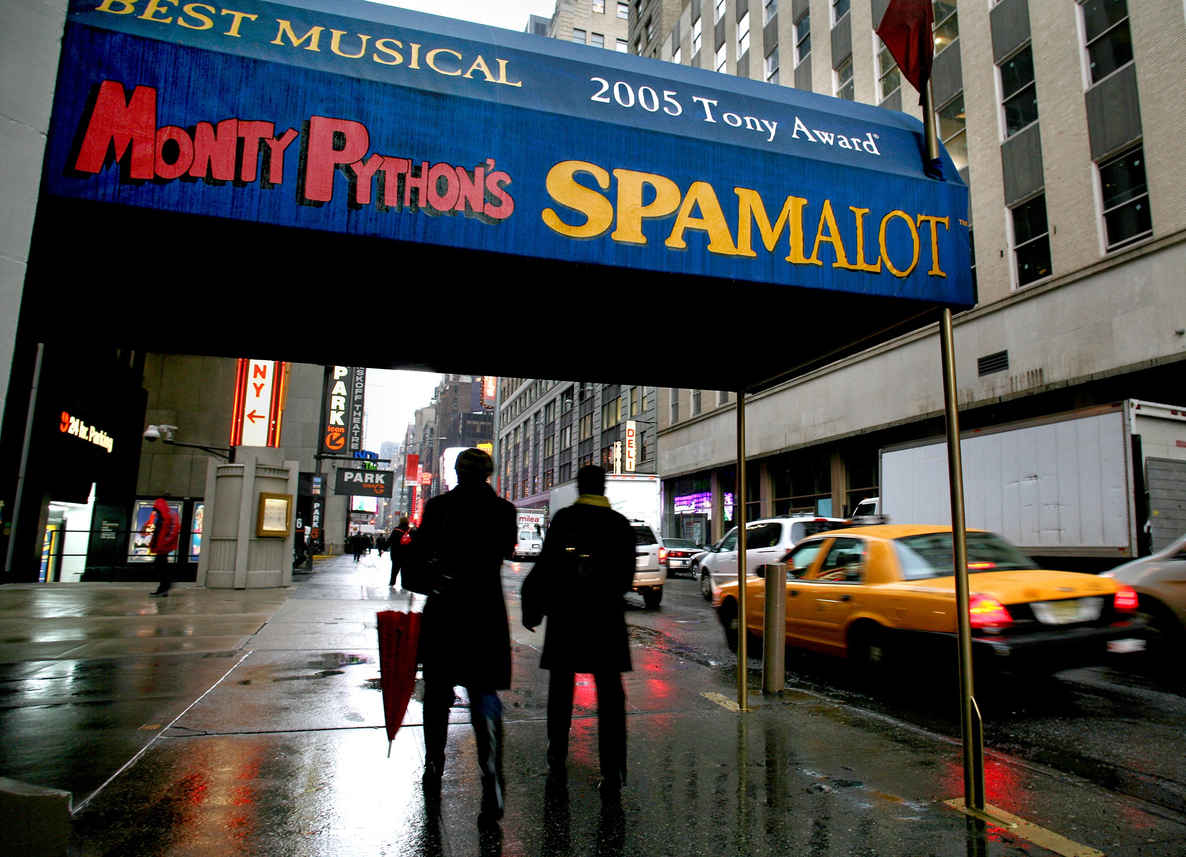 Pedestrians walk under the marquee of the Broadway show ‘Monty Python's Spamalot’ in New York