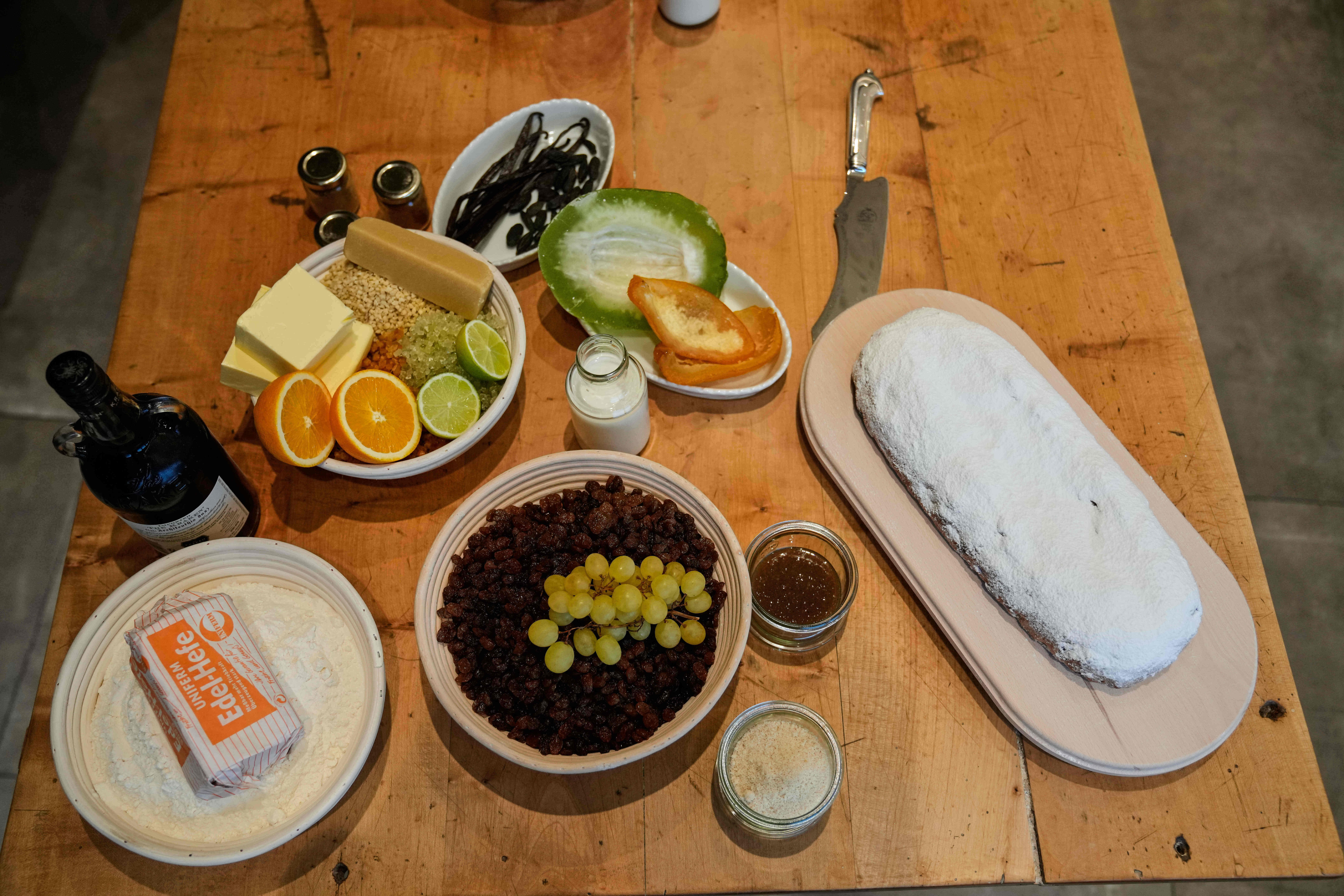 A stollen pastry, a traditional Christmas pastry, sits on a table in a bakery along with pastry ingredients.