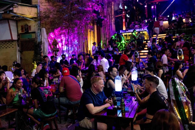 <p>People enjoy a drink at a bar along the popular tourist and nightlife strip Khao San Road in Bangkok on December 10, 2021. (Photo by Jack TAYLOR / AFP) (Photo by JACK TAYLOR/AFP via Getty Images)</p>