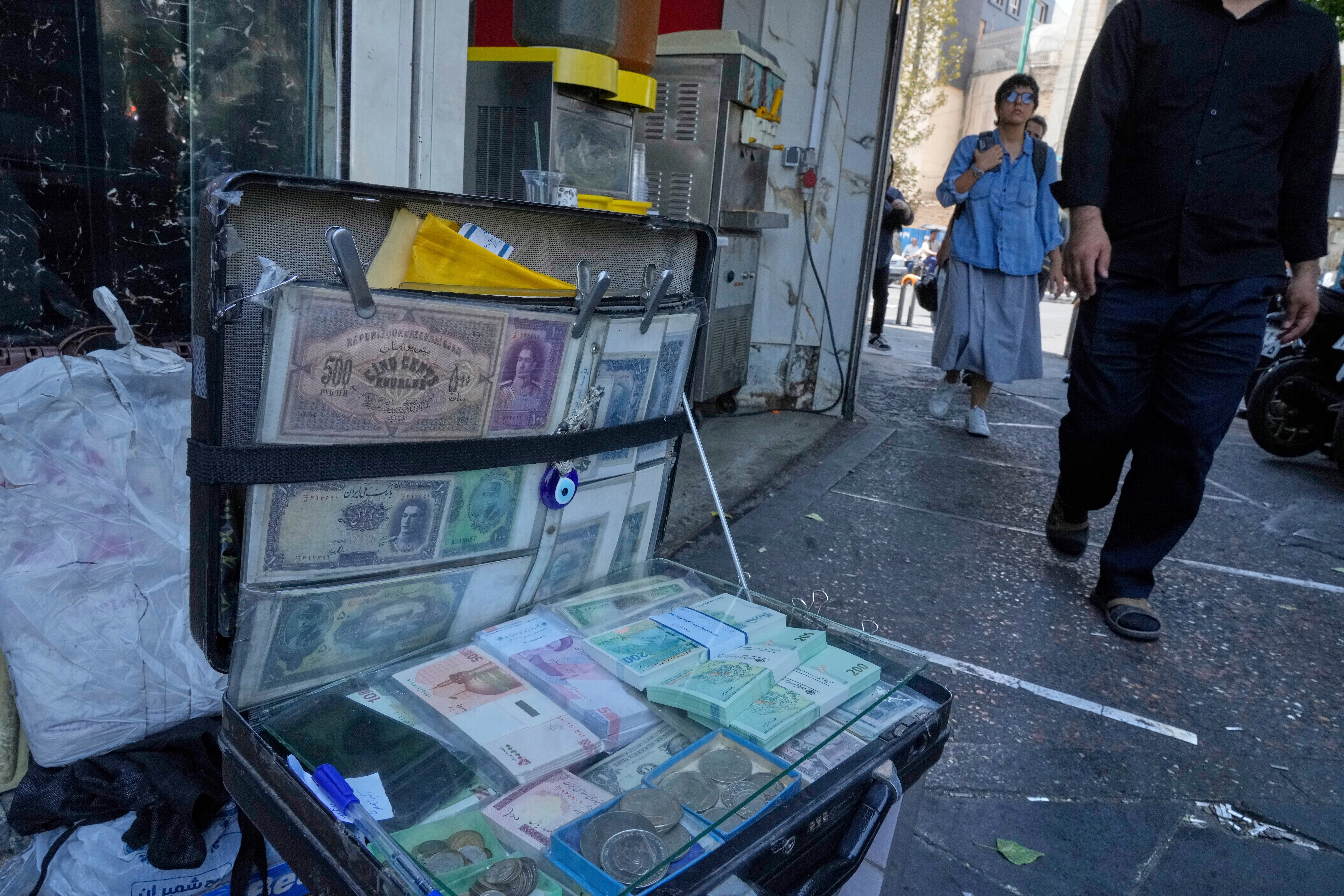 Current and pre-revolution Iranian banknotes are displayed by a street money exchanger