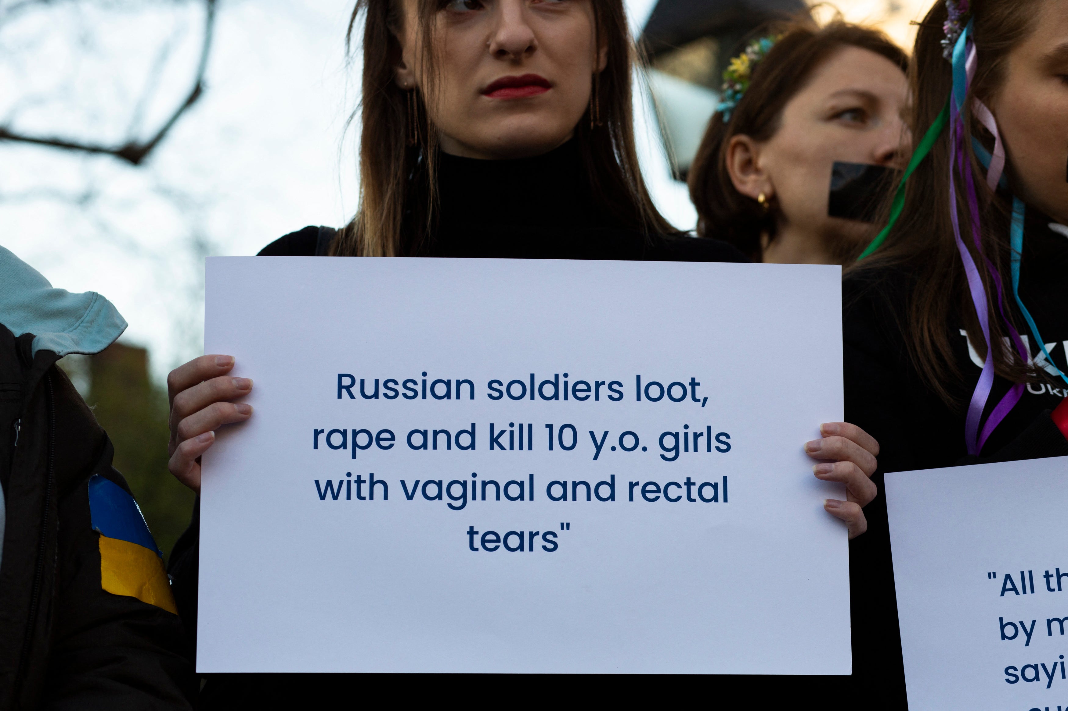 A woman holds a sign denouncing sexual atrocities during a protest against sexual abuse by Russian soldiers in Ukraine, at Washington Square Park in New York City, in April 2022