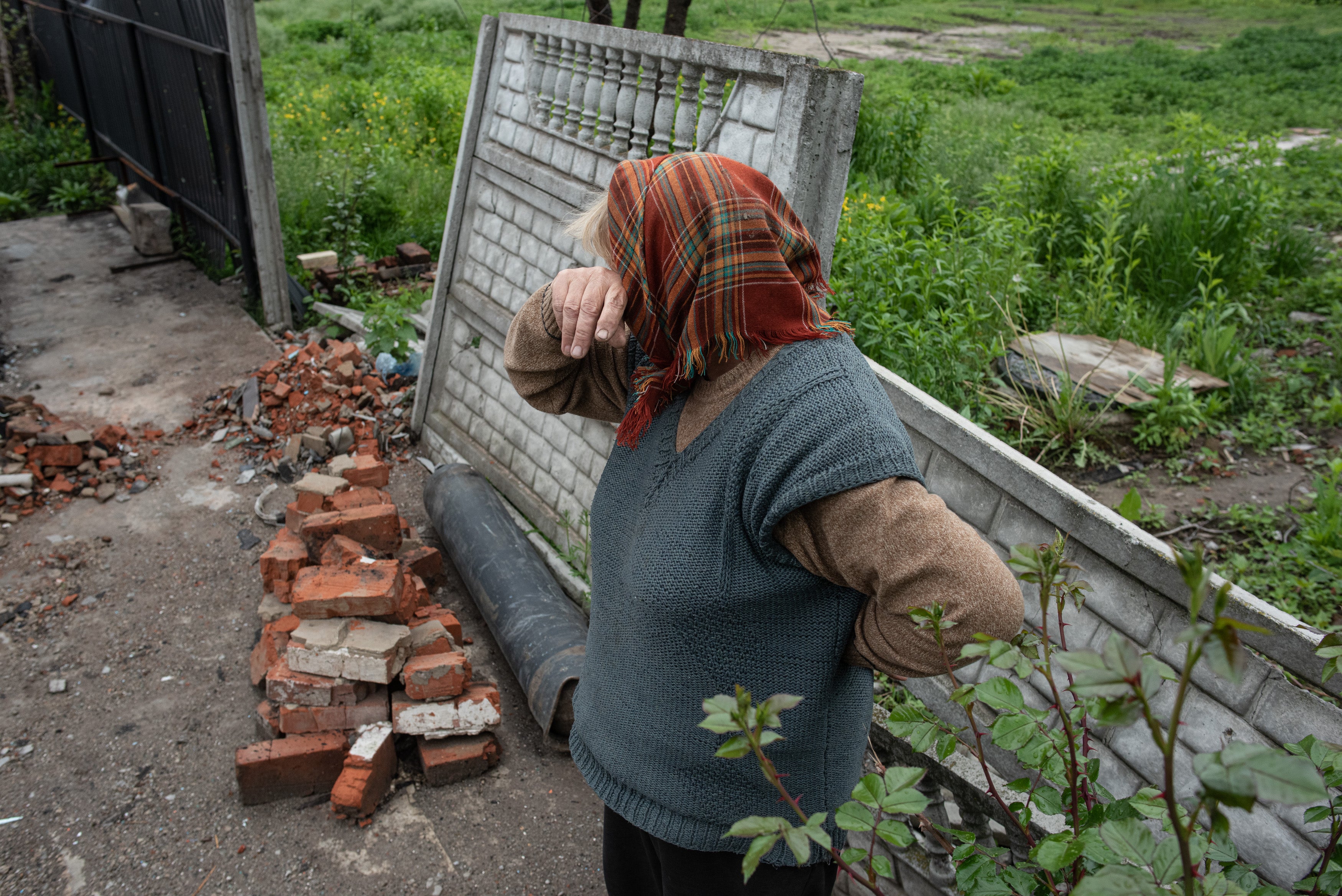A woman cries in front of her burned house in May 2022 in Novoselivka, Ukraine