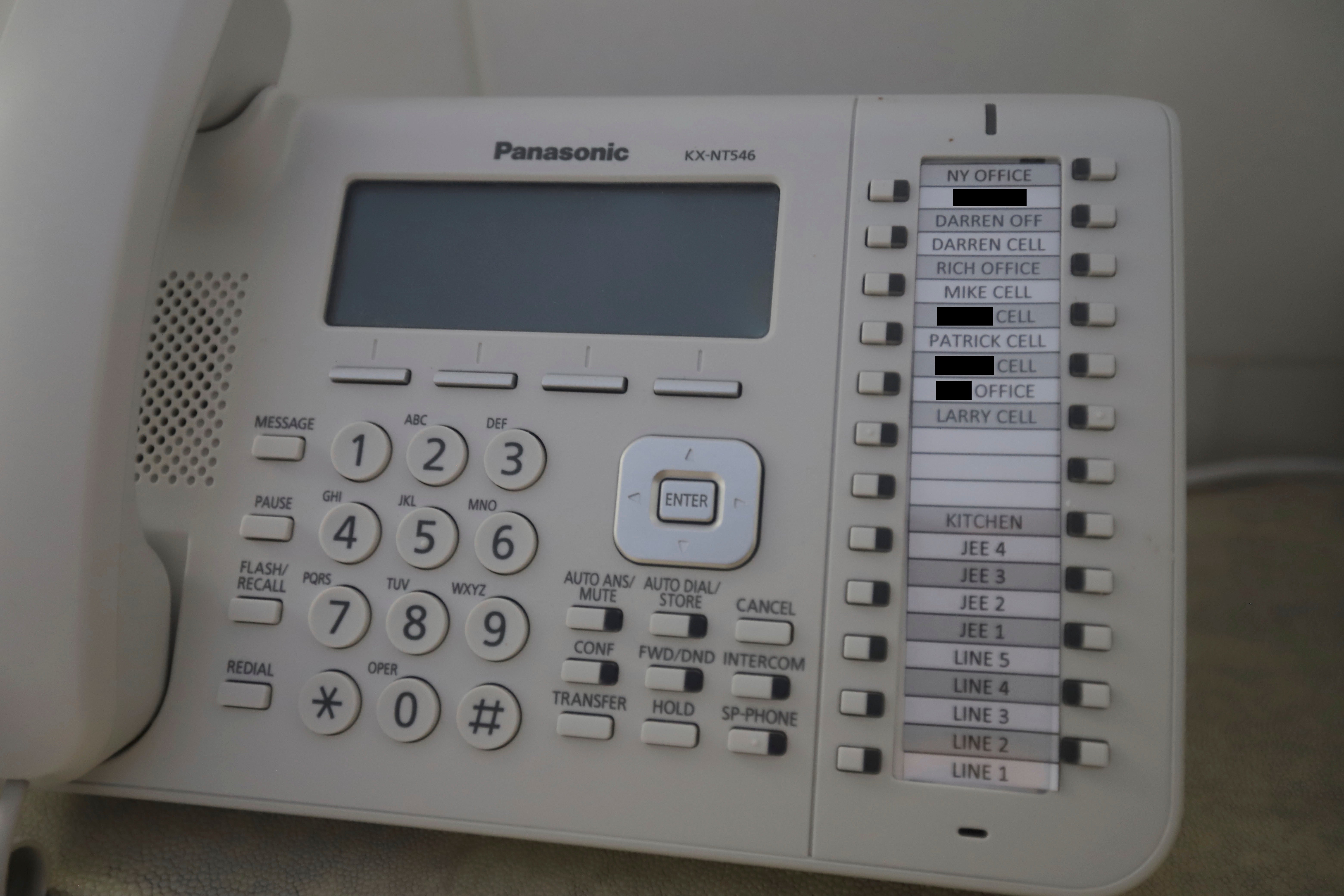 A landline telephone, photographed inside Epstein’s home, features several names on speed dial, some redacted