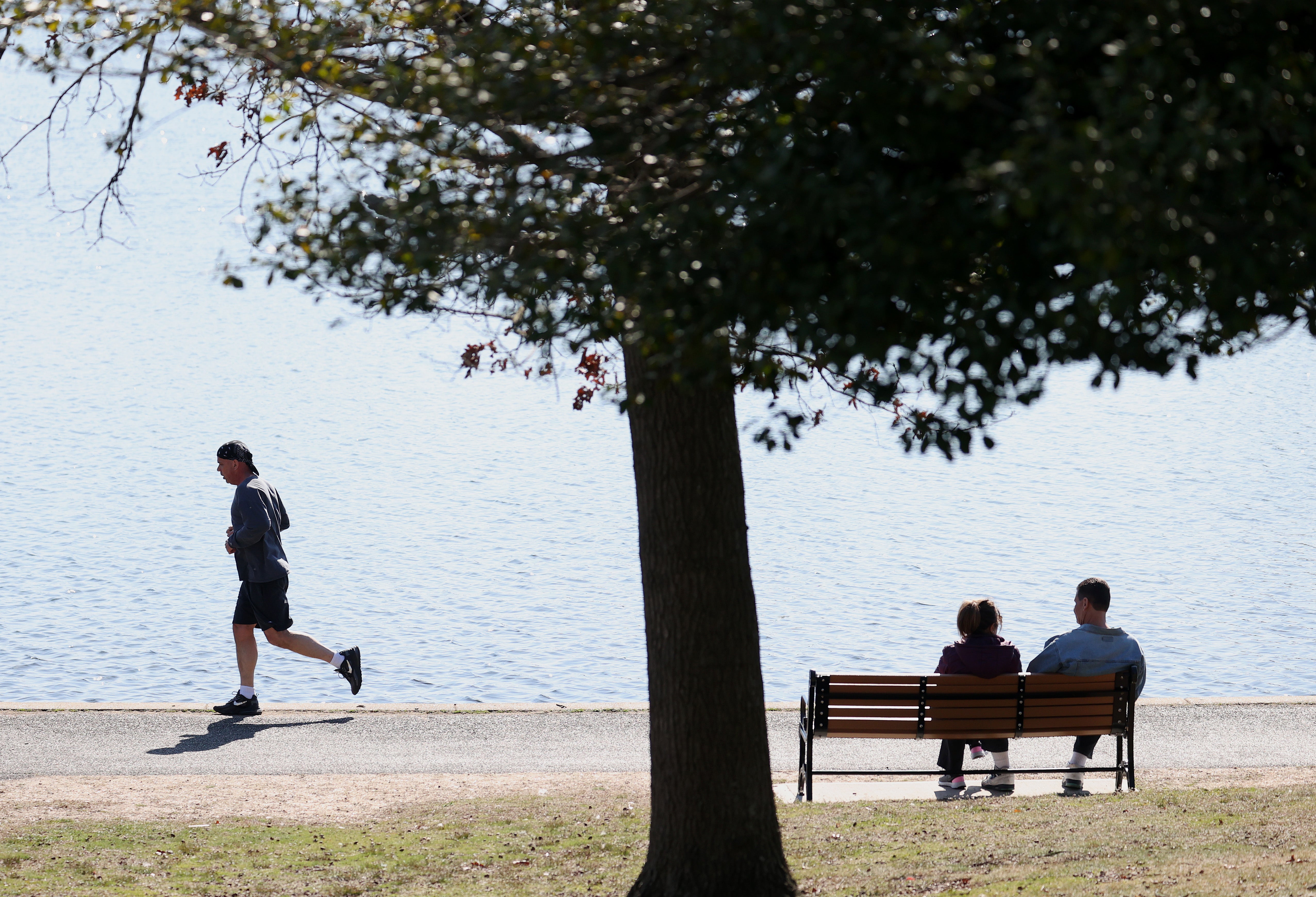 Duas pessoas sentadas em um banco de parque em East Meadow, Nova York. A amizade pode ajudar a prevenir sentimentos de solidão