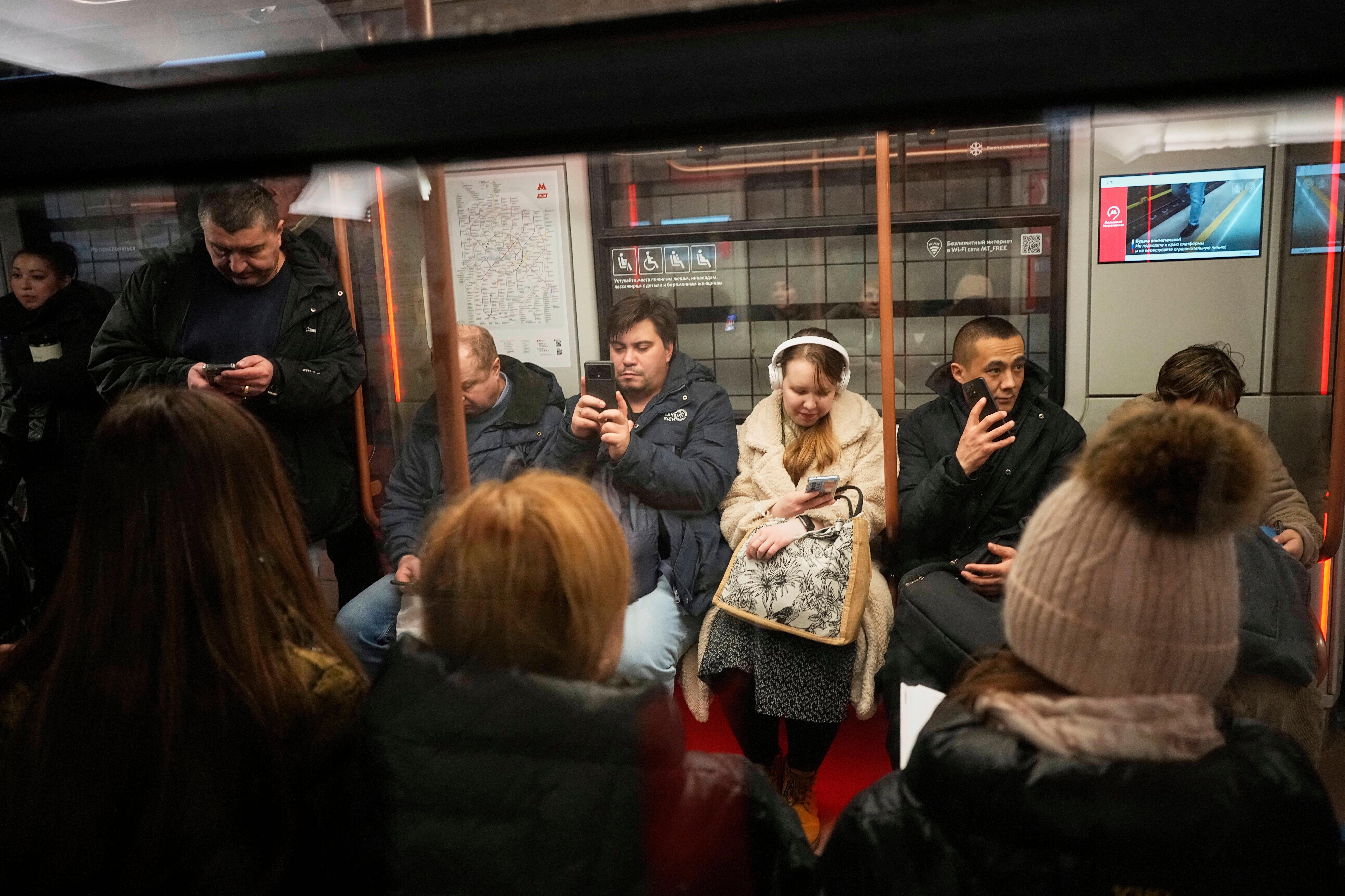 Passengers look at their smartphones while on the subway in Moscow, Russia, March 4, 2025