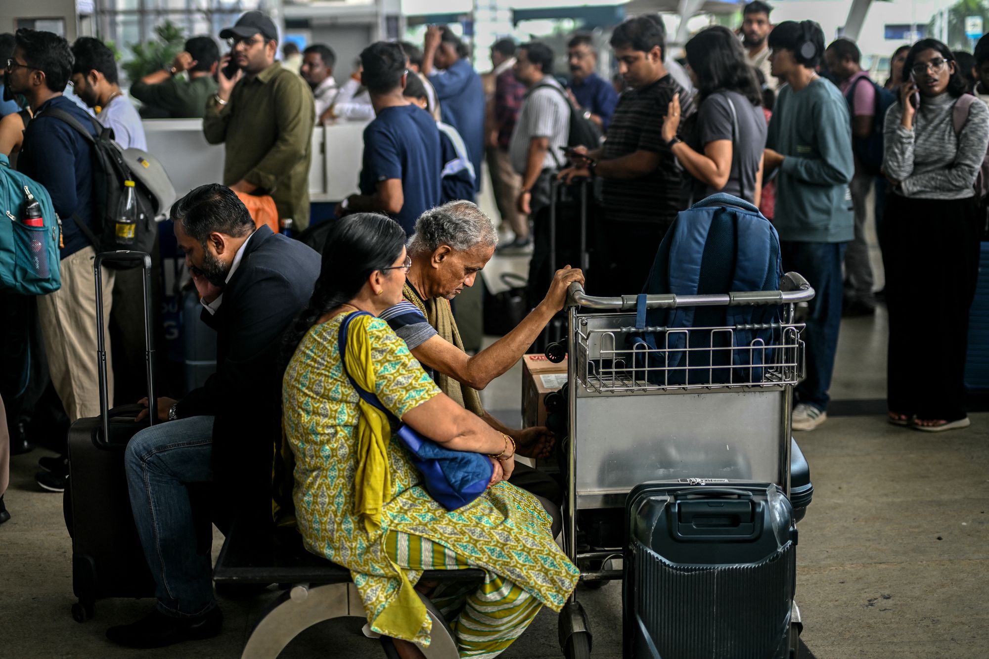 Passengers wait near an IndiGo kiosk at the Chennai airport
