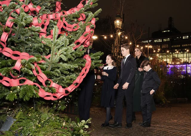 <p>The Prince and Princess of Wales and their children look at messages on the Connection Tree (Jordan Pettitt/PA)</p>