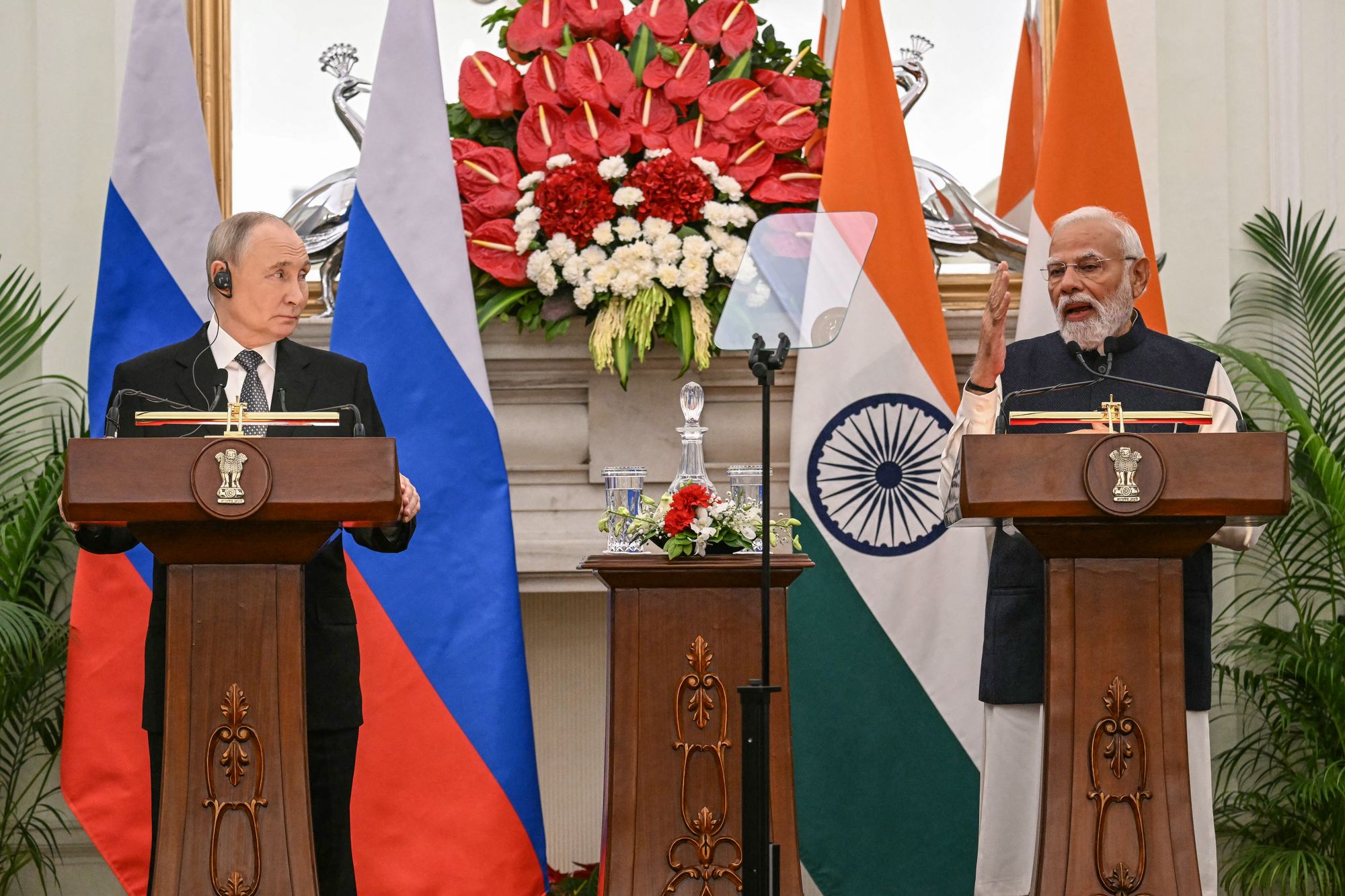 Russia's President Vladimir Putin (L) listens as India's Prime Minister Narendra Modi speaks during the joint press statements after their meeting at the Hyderabad House in New Delhi on December 5, 2025. (Photo by Sajjad HUSSAIN / AFP via Getty Images)