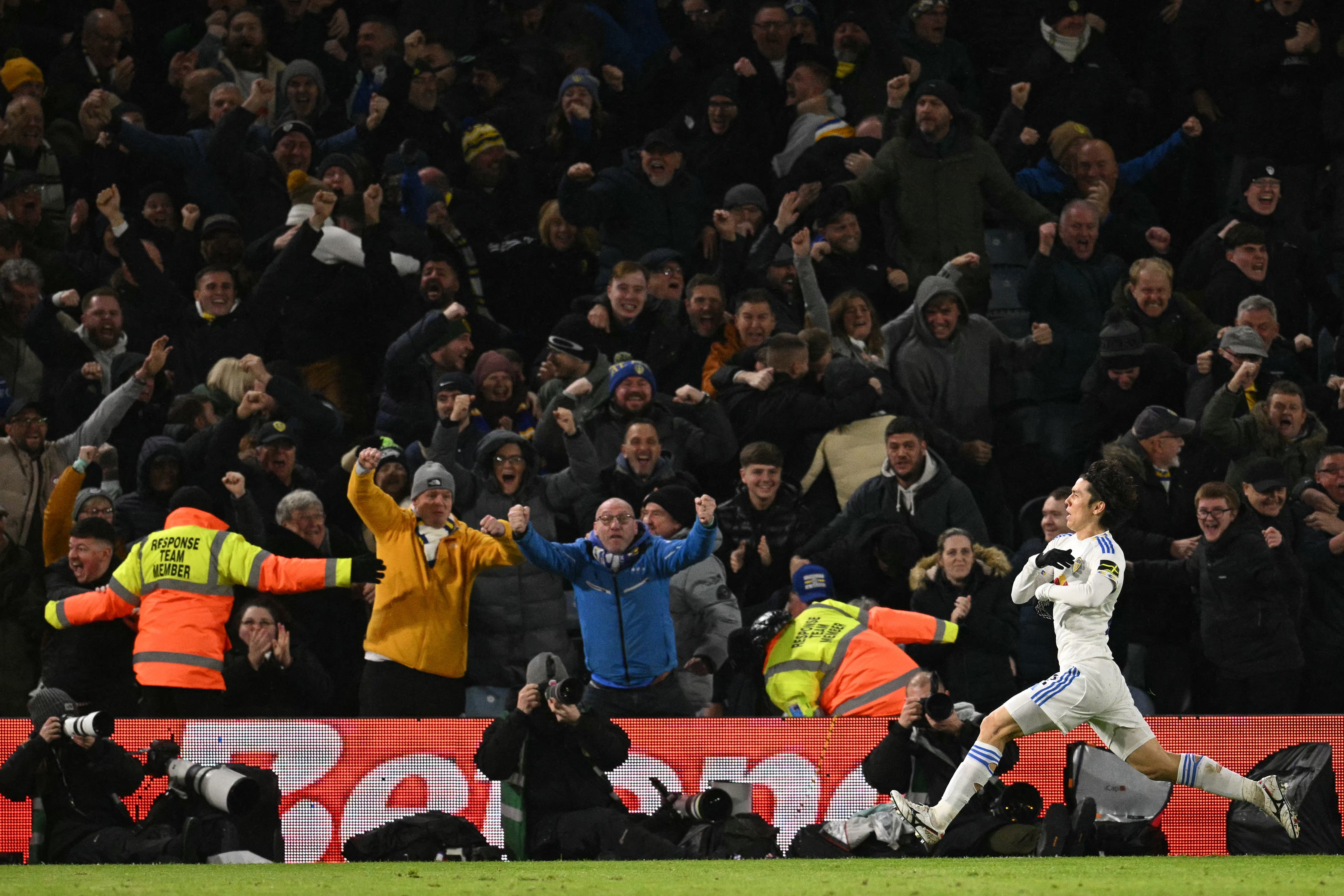 Leeds fans celebrate as Tanaka slides after scoring