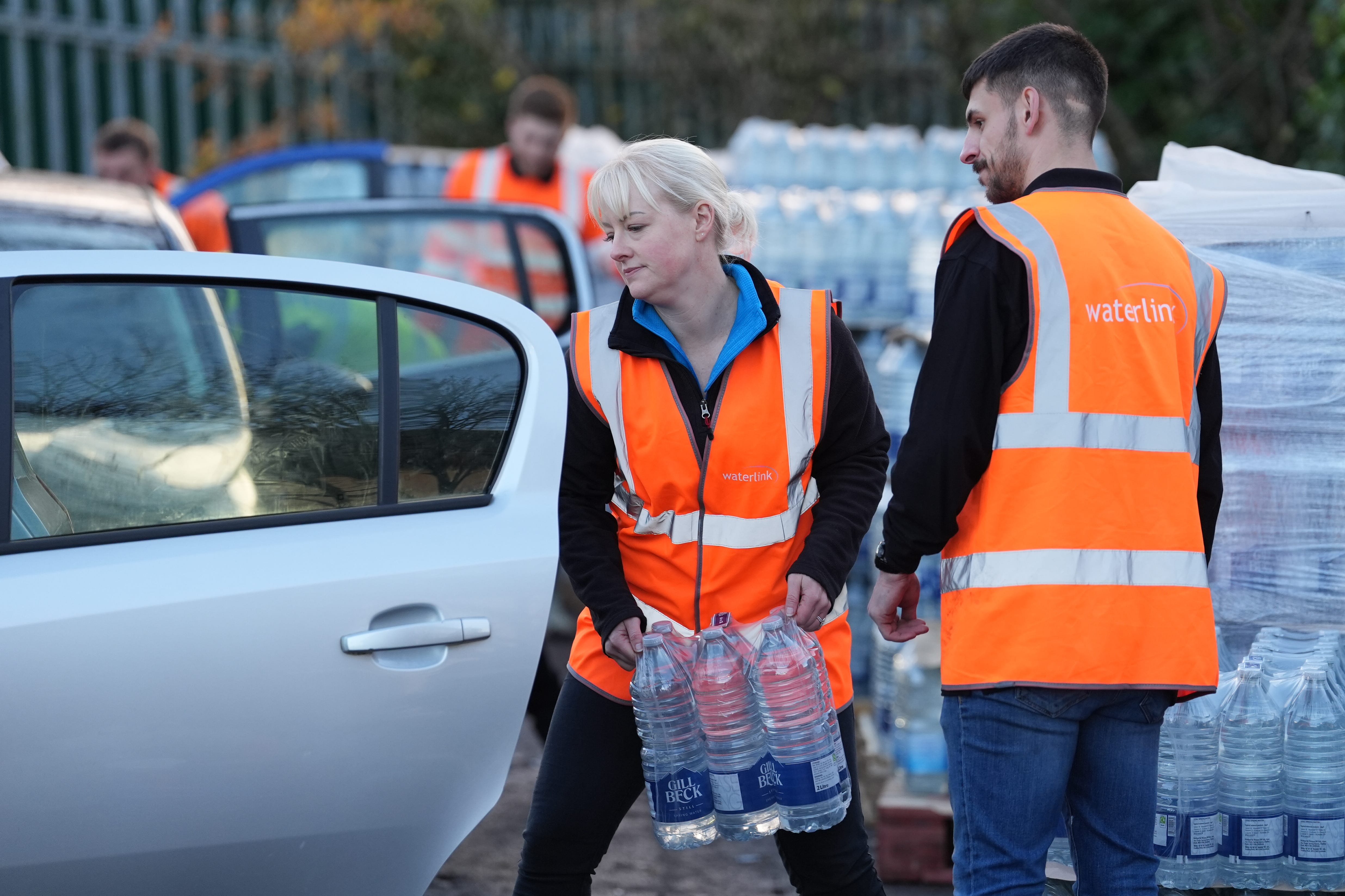 A worker hands out bottled water at the Tunbridge Wells sports centre Gareth Fuller(/PA)
