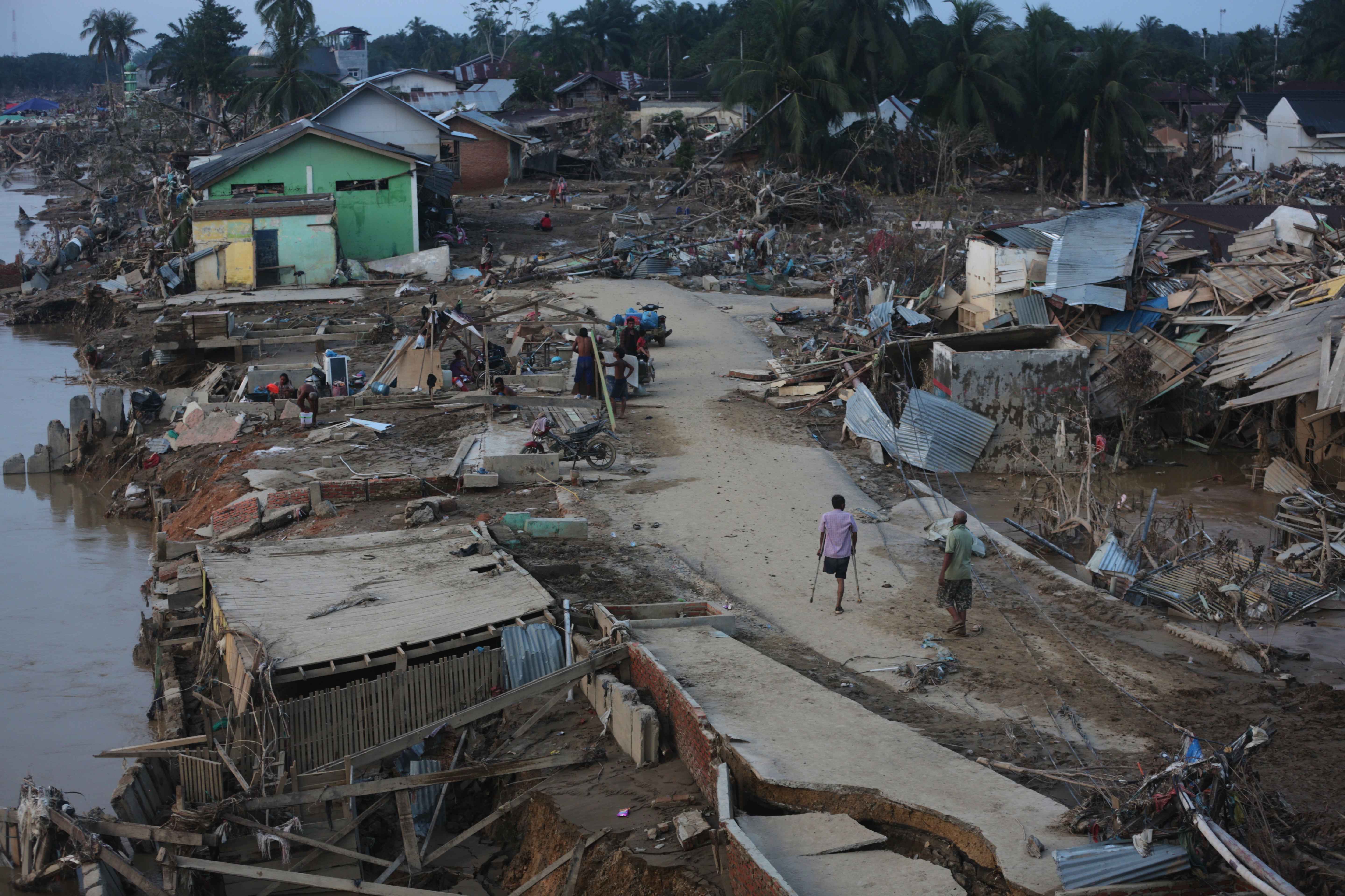 Survivors walk at an area affected by flash flood in Aceh Tamiang, on Sumatra Island, Indonesia.