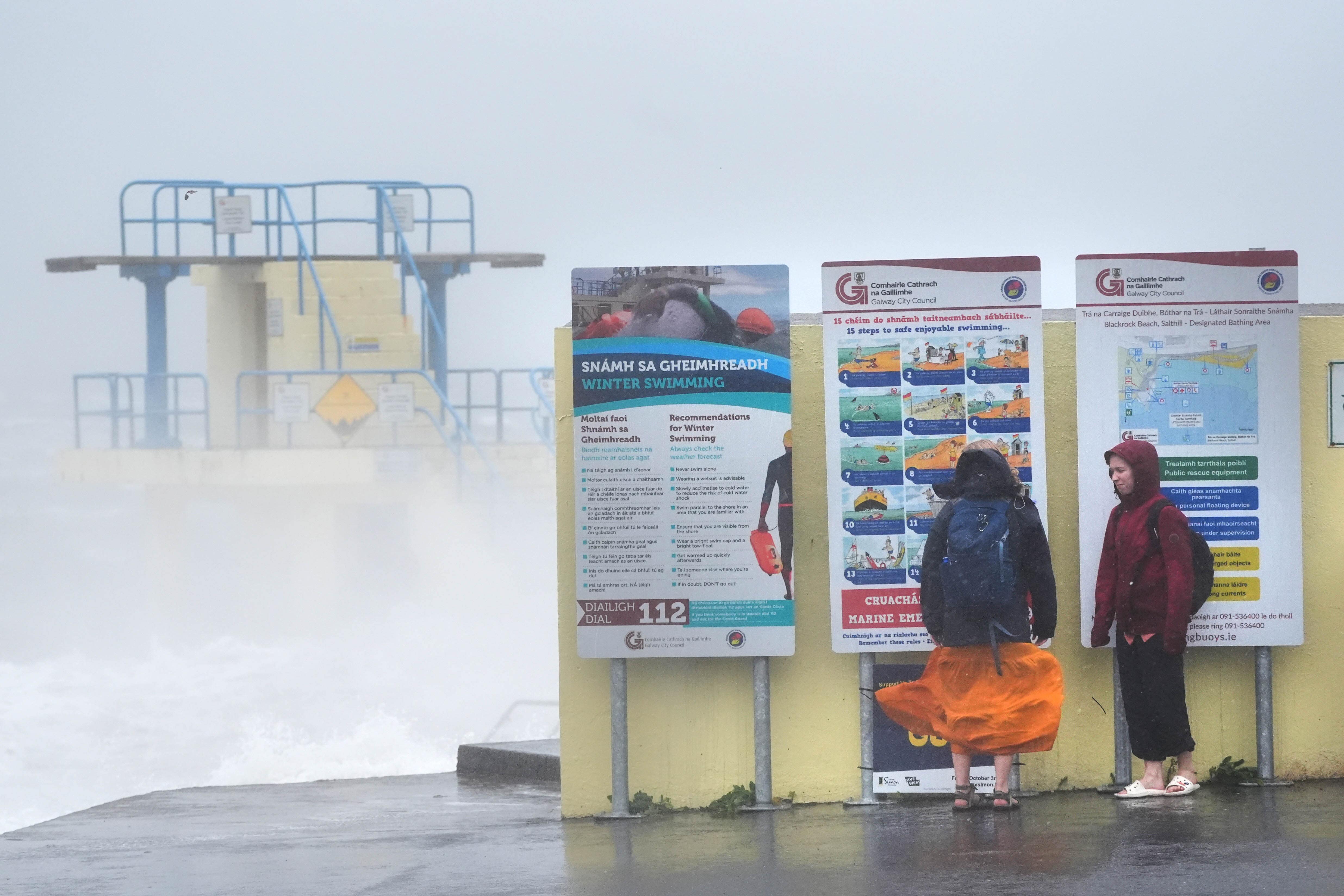 People by Blackrock diving tower in Salthill, Galway during strong winds earlier in the year (Brian Lawless/PA)