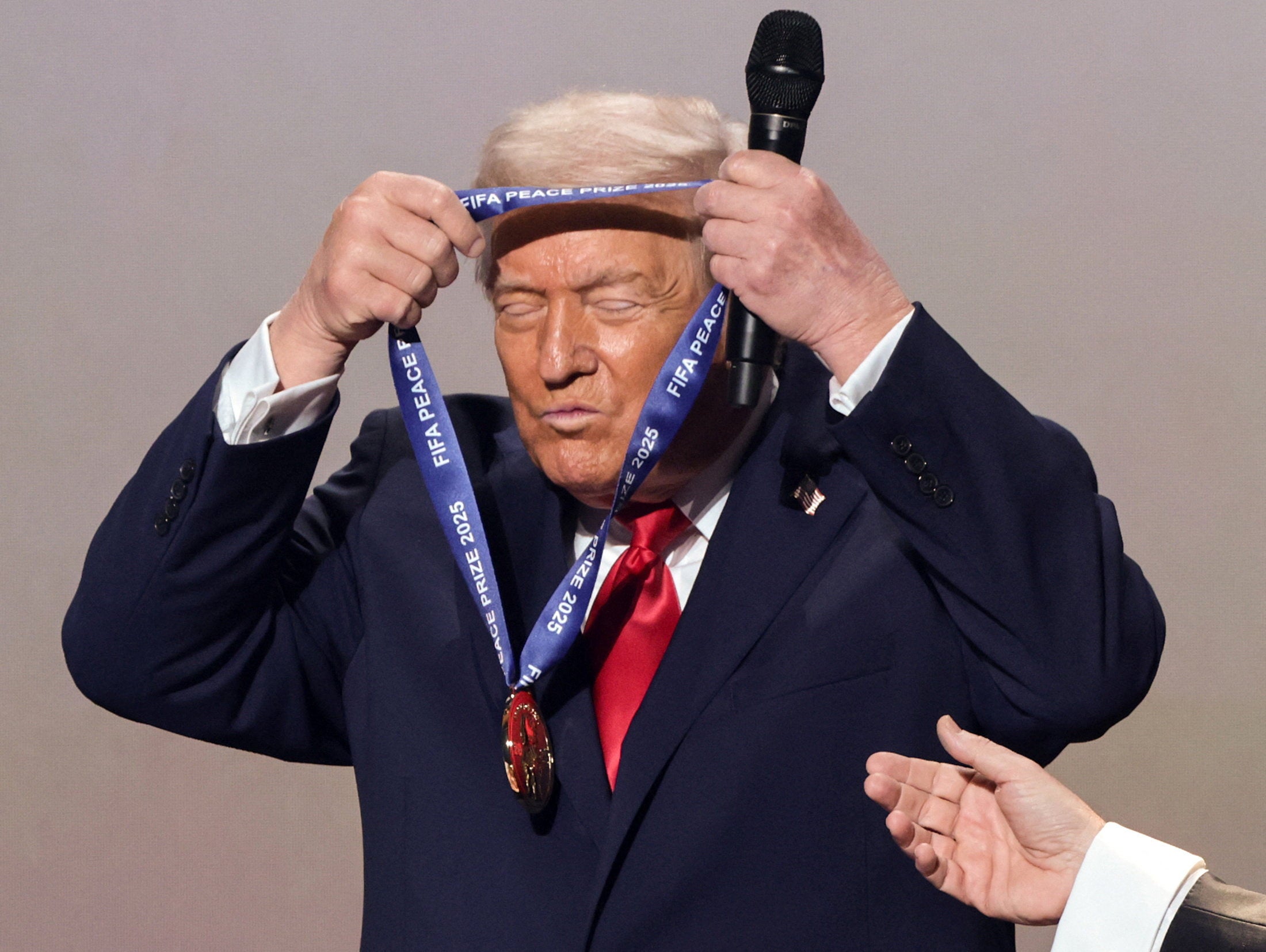 U.S. President Donald Trump places the medal on himself as he is awarded the FIFA Peace Prize at the Kennedy Center in Washington, D.C.