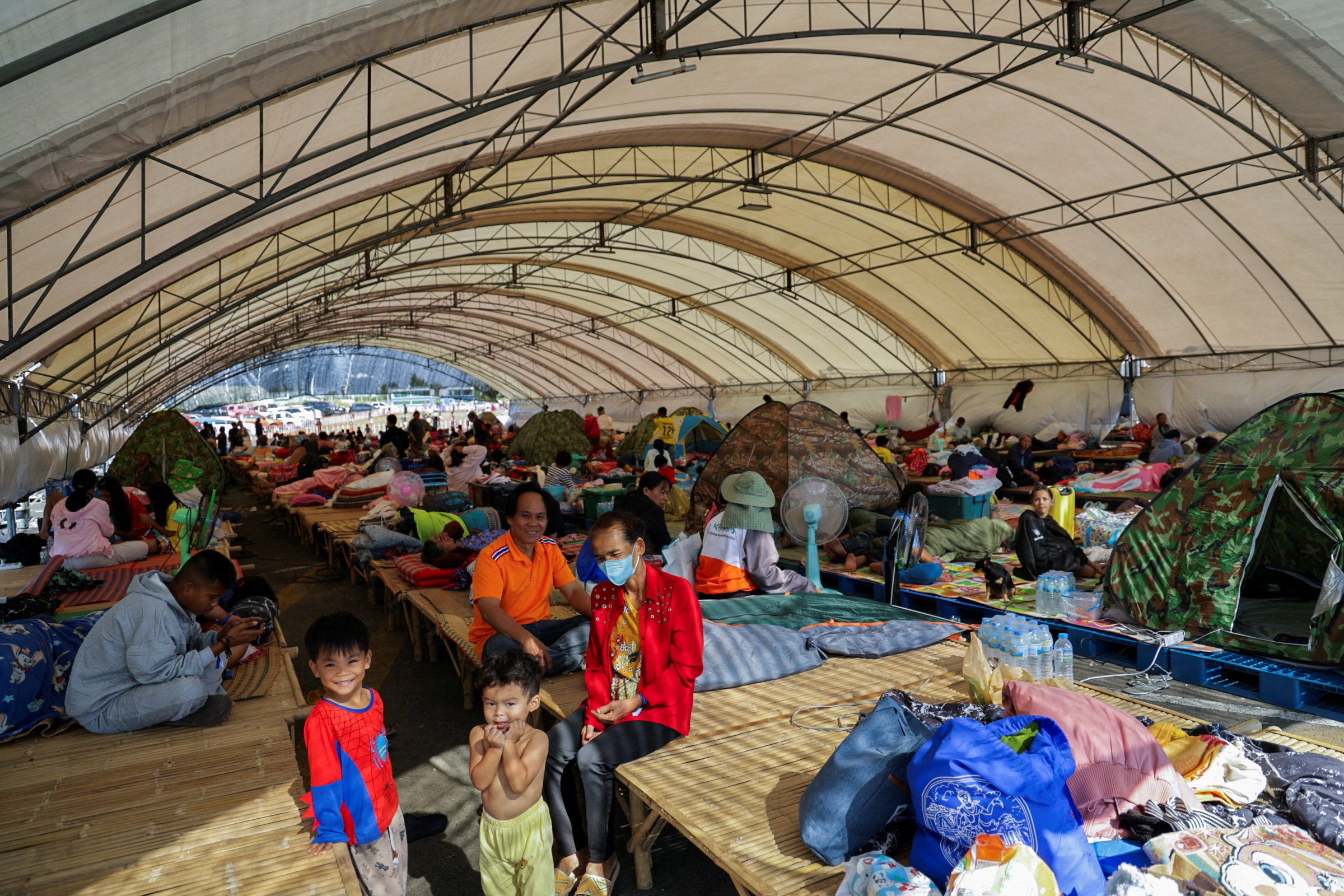People rest at a shelter, following fresh military clashes between Thailand and Cambodia along parts of their disputed border, in Buriram province, Thailand